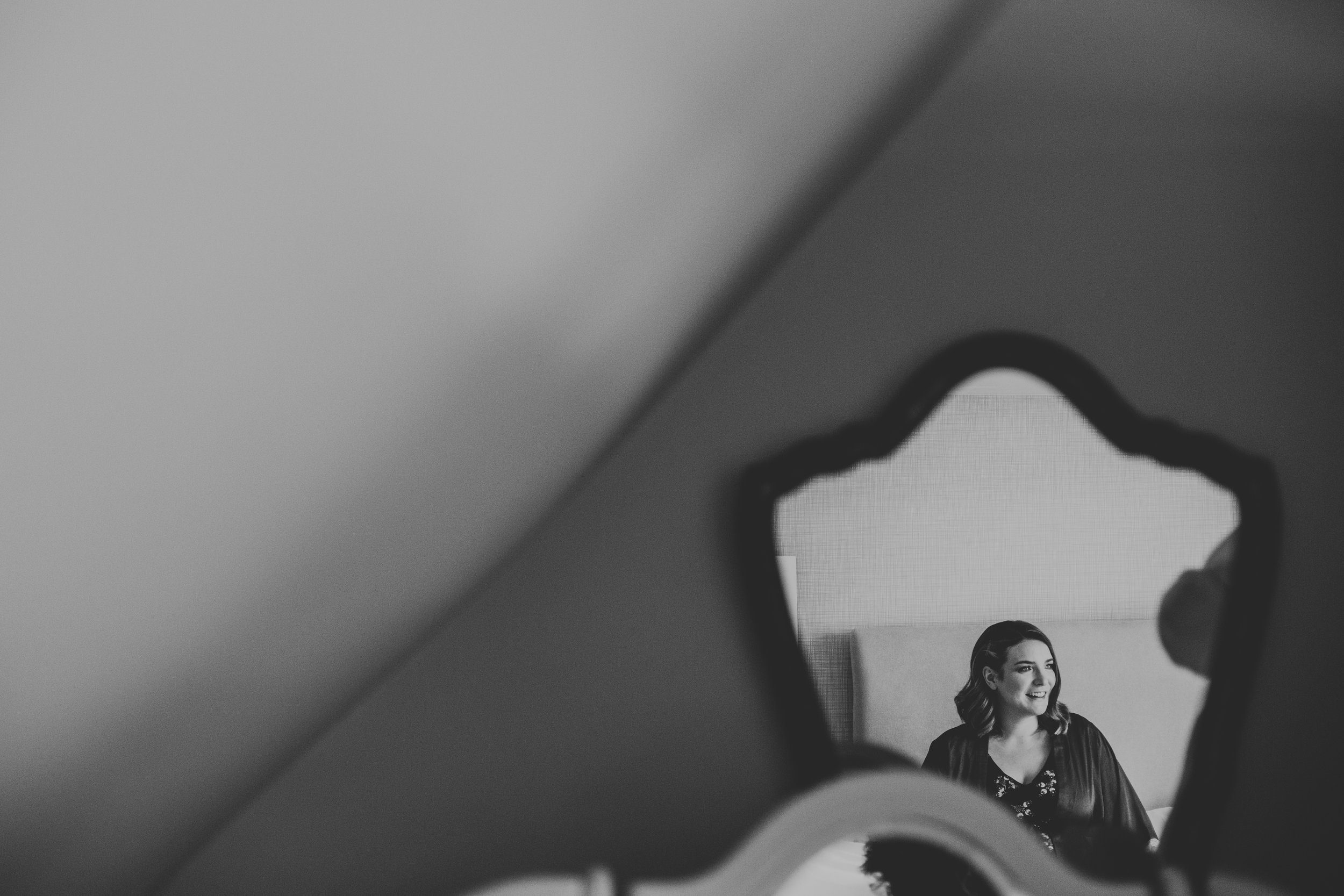Reflection of bridesmaid in mirror. Photo in black and white. 