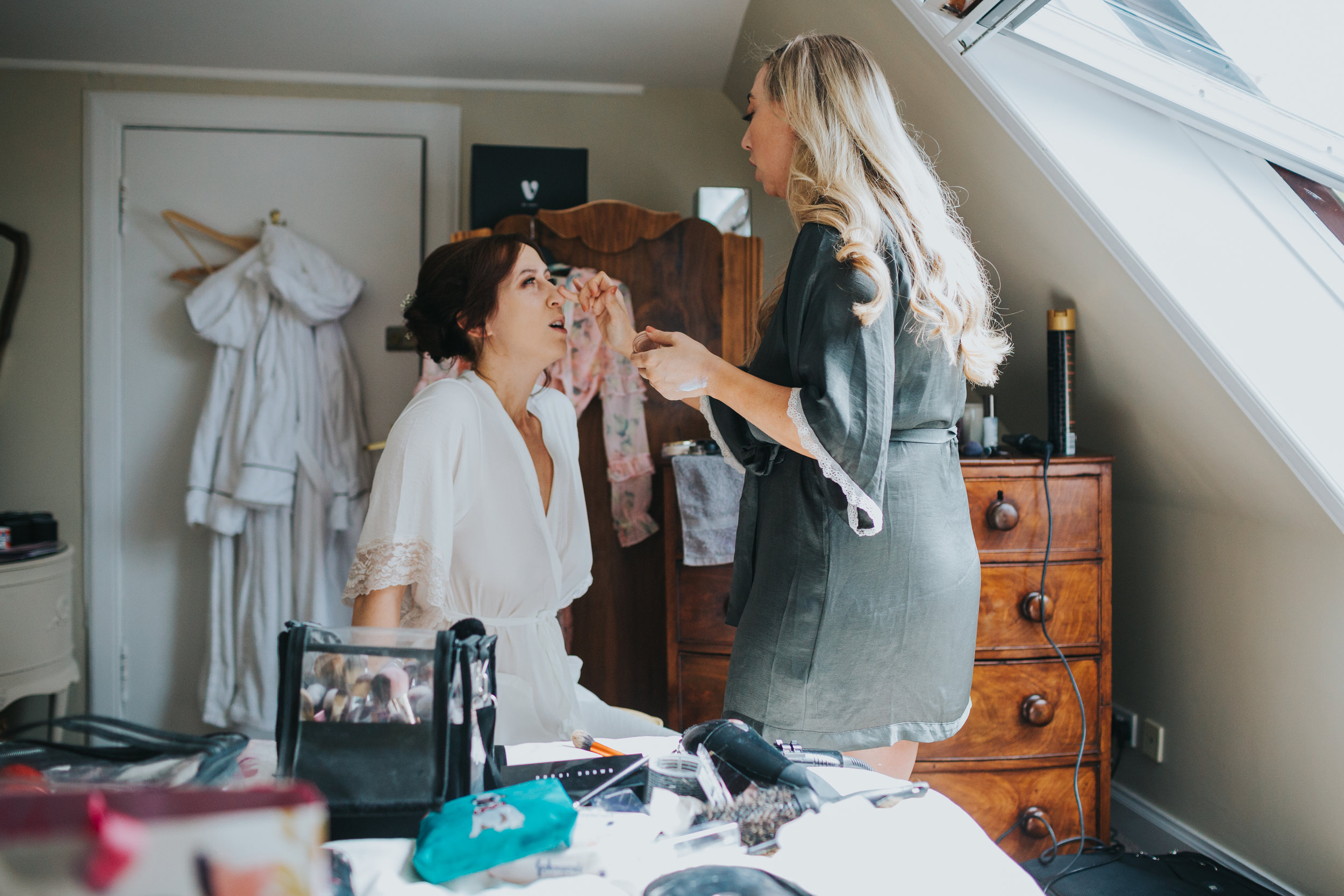 Bride has finishing touches added to her make up. 