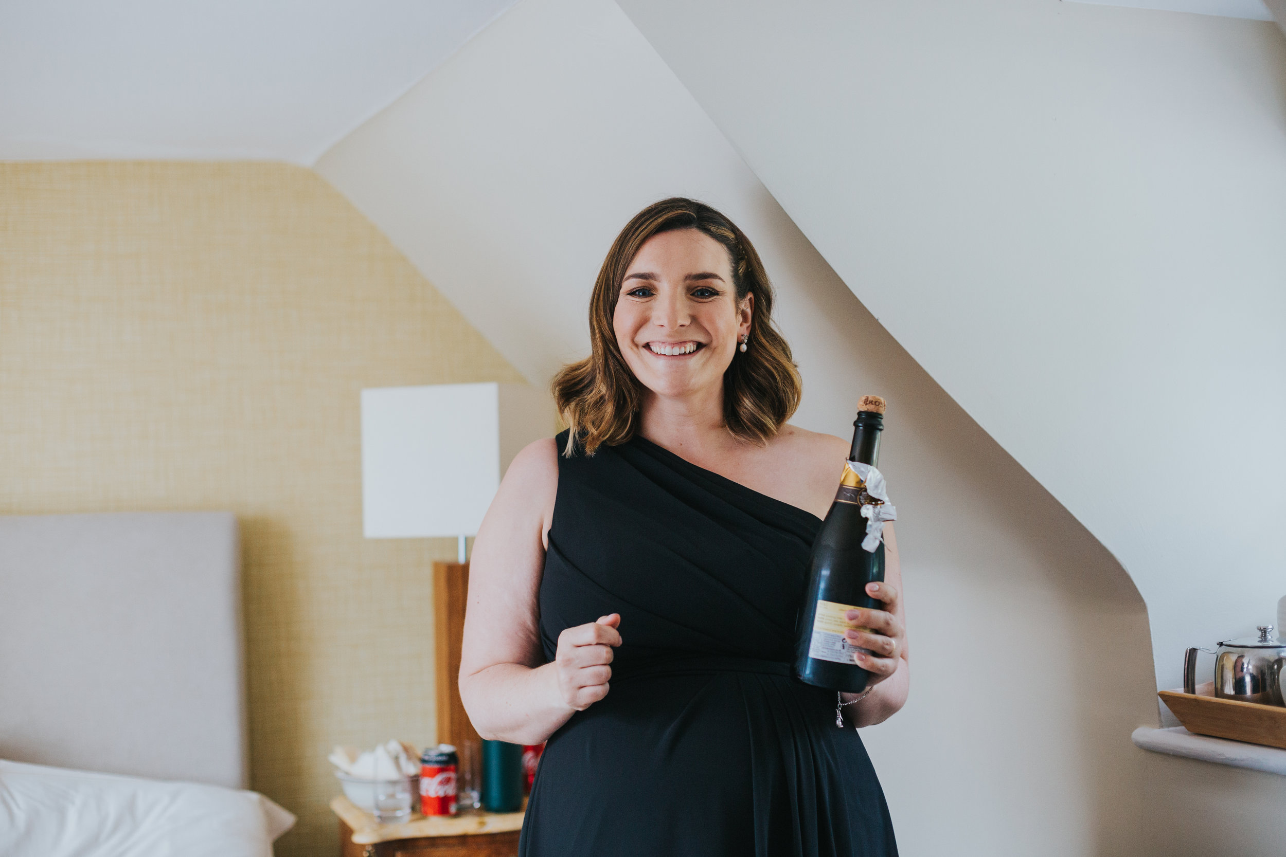 Bridesmaid opens the champagne. 