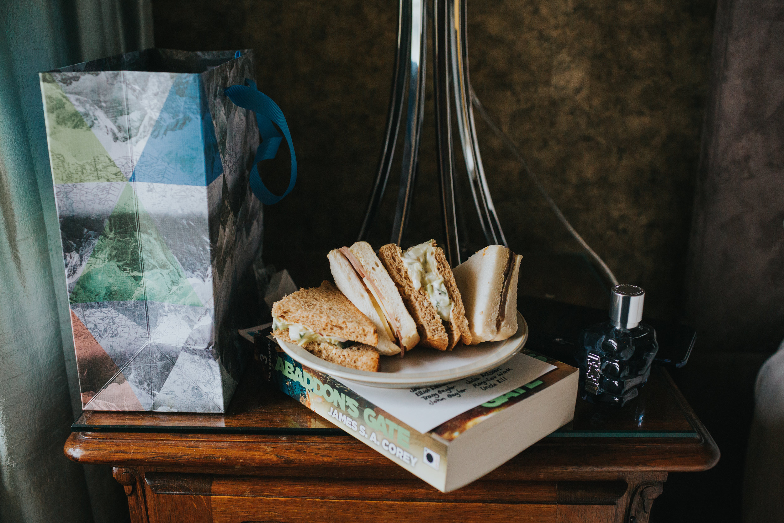 Grooms morning sandwiches on top of book and next to his aftershave.  