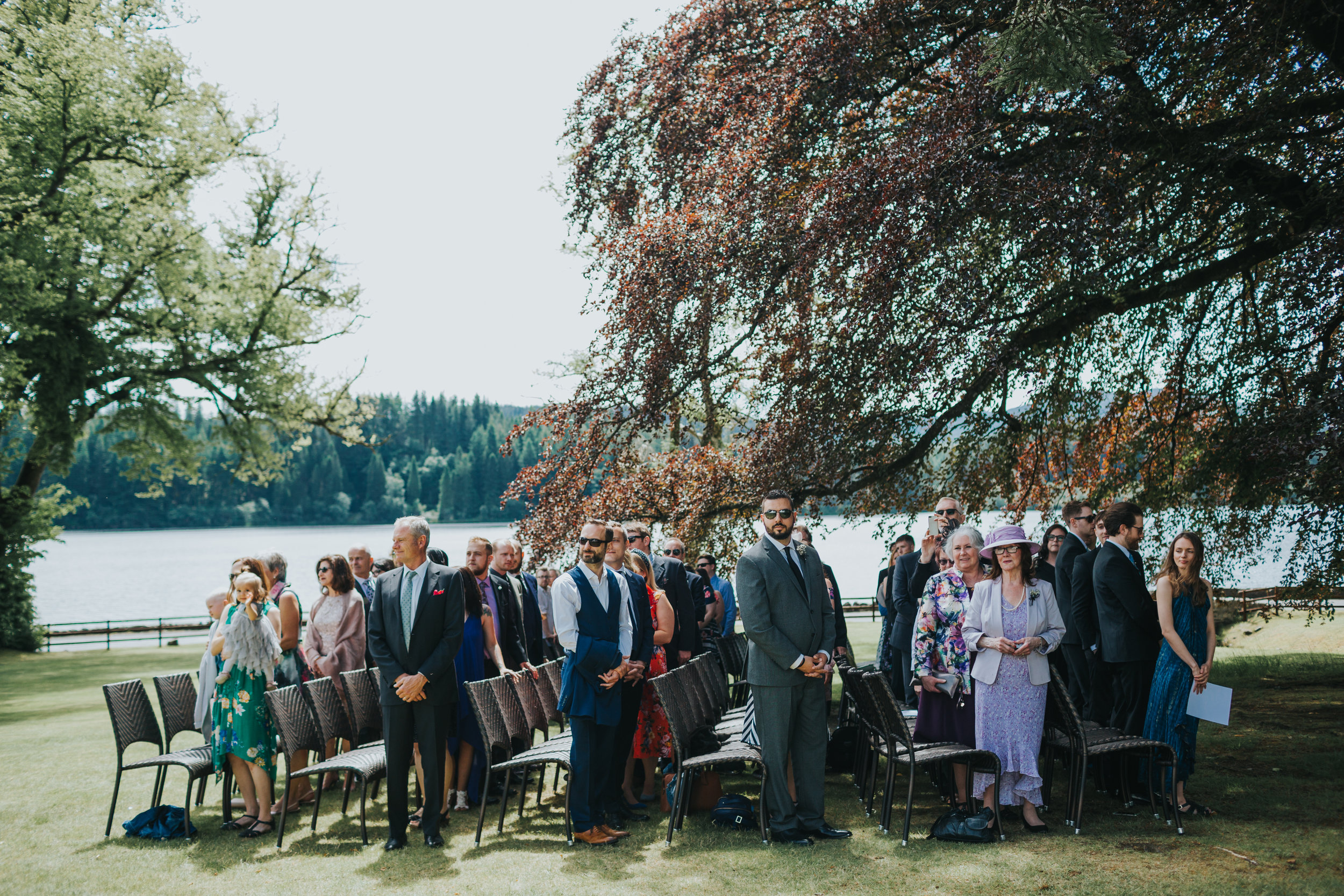 Wedding guests stand to receive the bride.