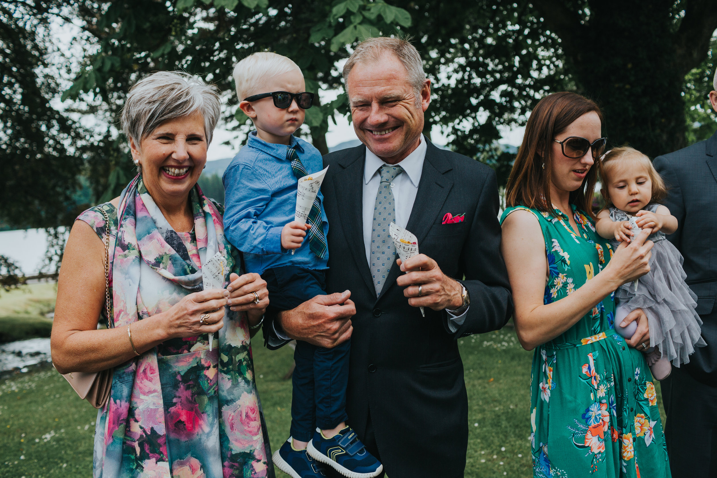 Family stands together with confetti waiting for the bride and groom. 