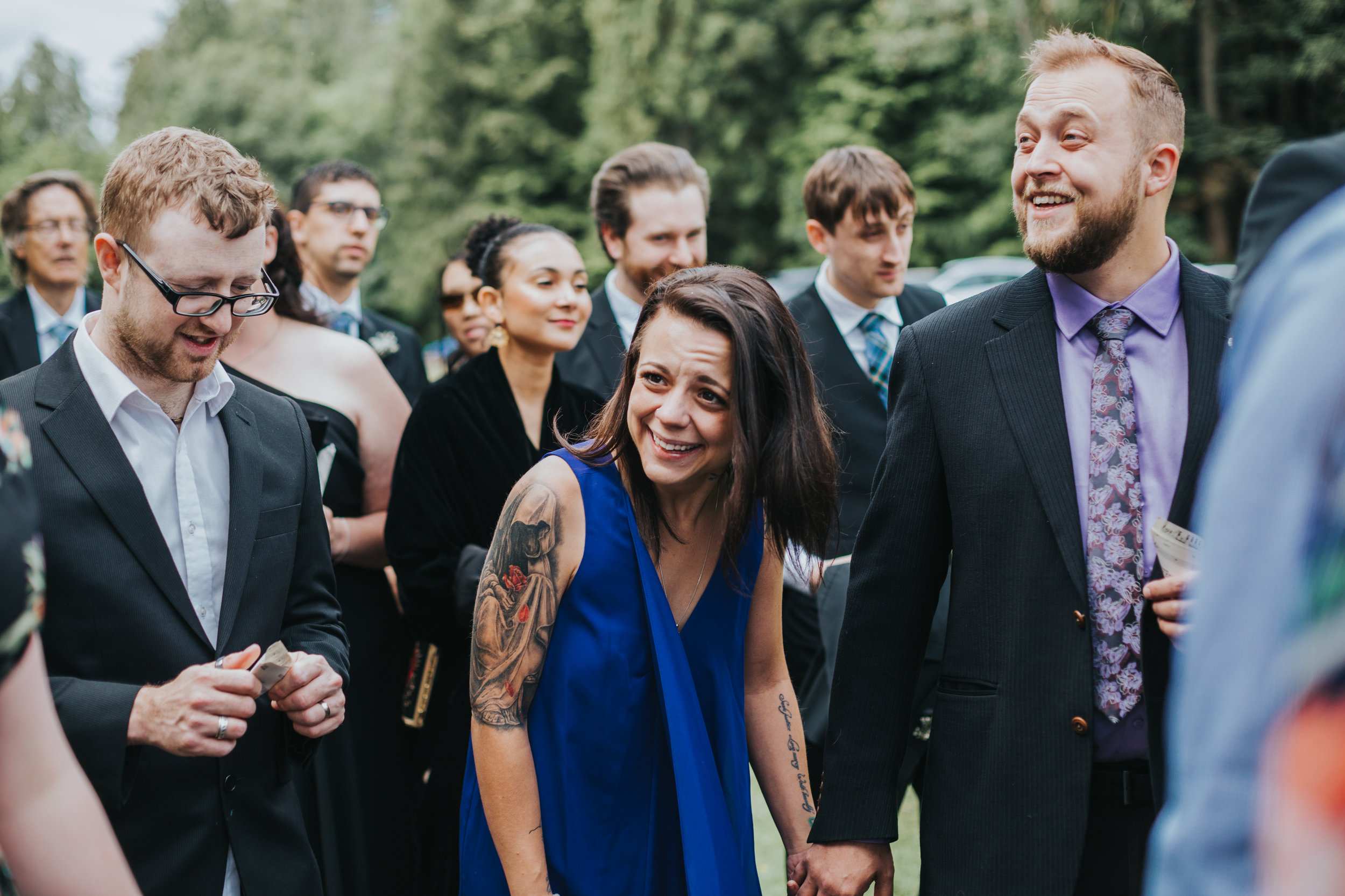 Wedding guests laugh together. 