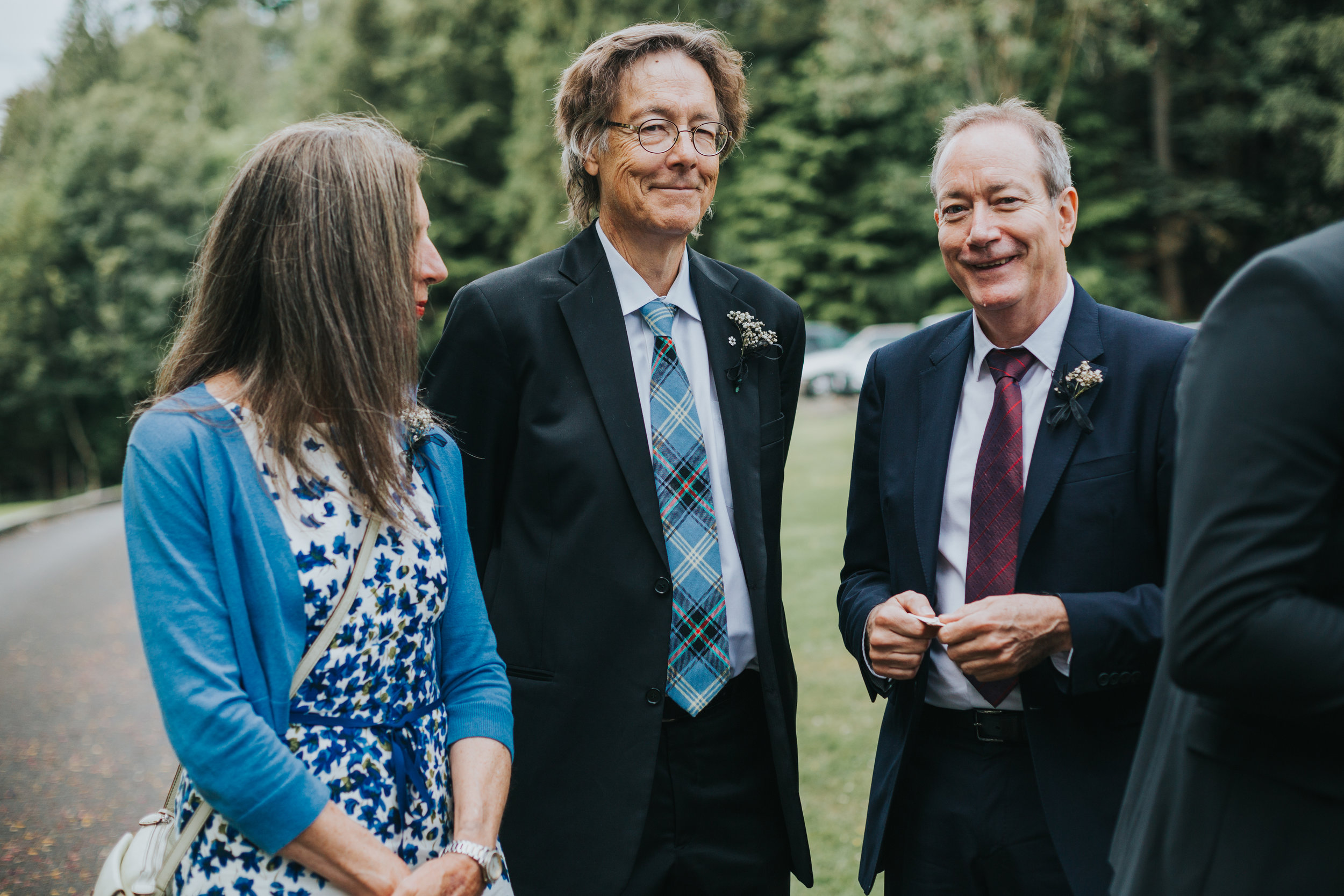 Wedding guests stand on the lawn together at Altkeith Country House , Scotland.