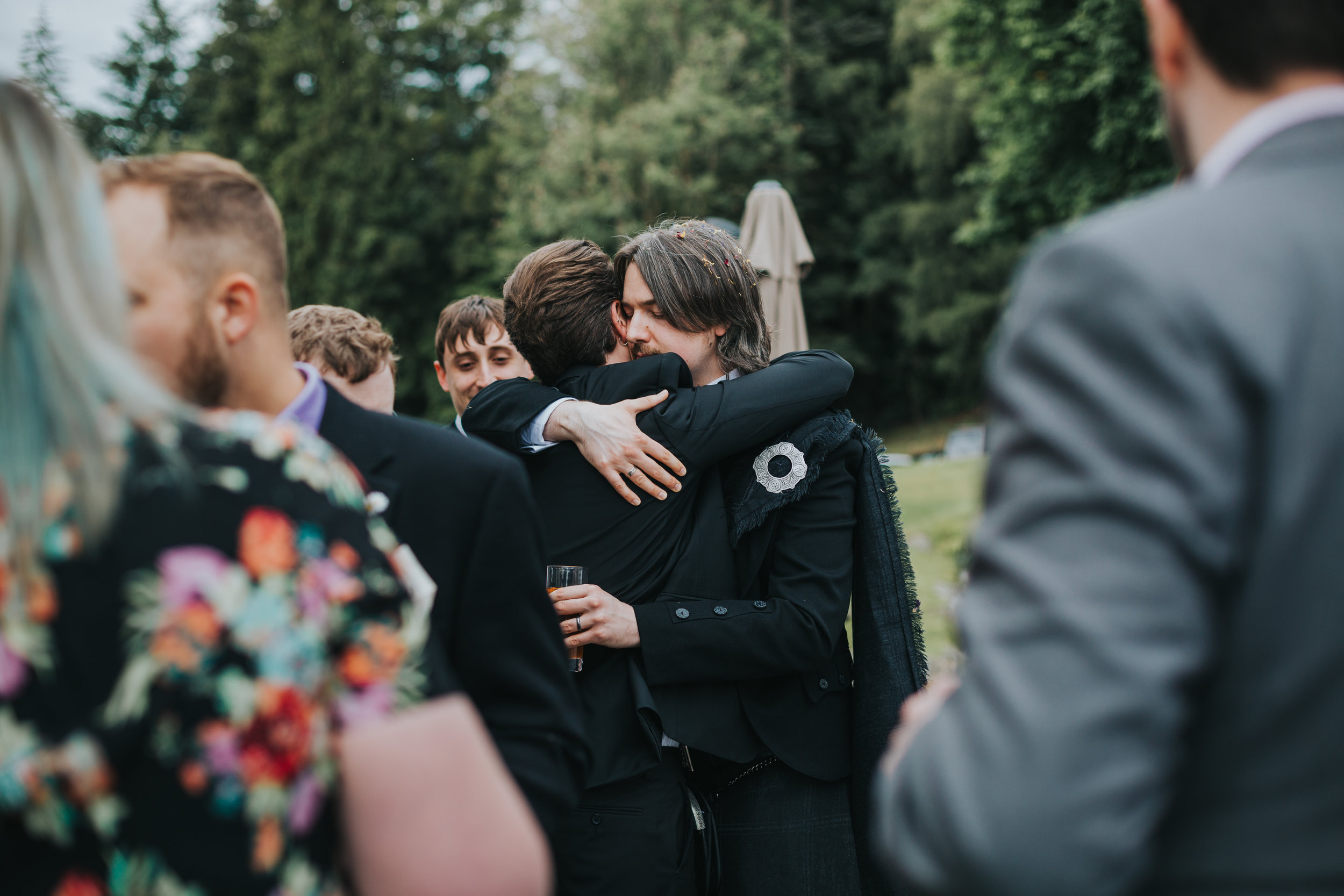 Groom hugs wedding guest. 