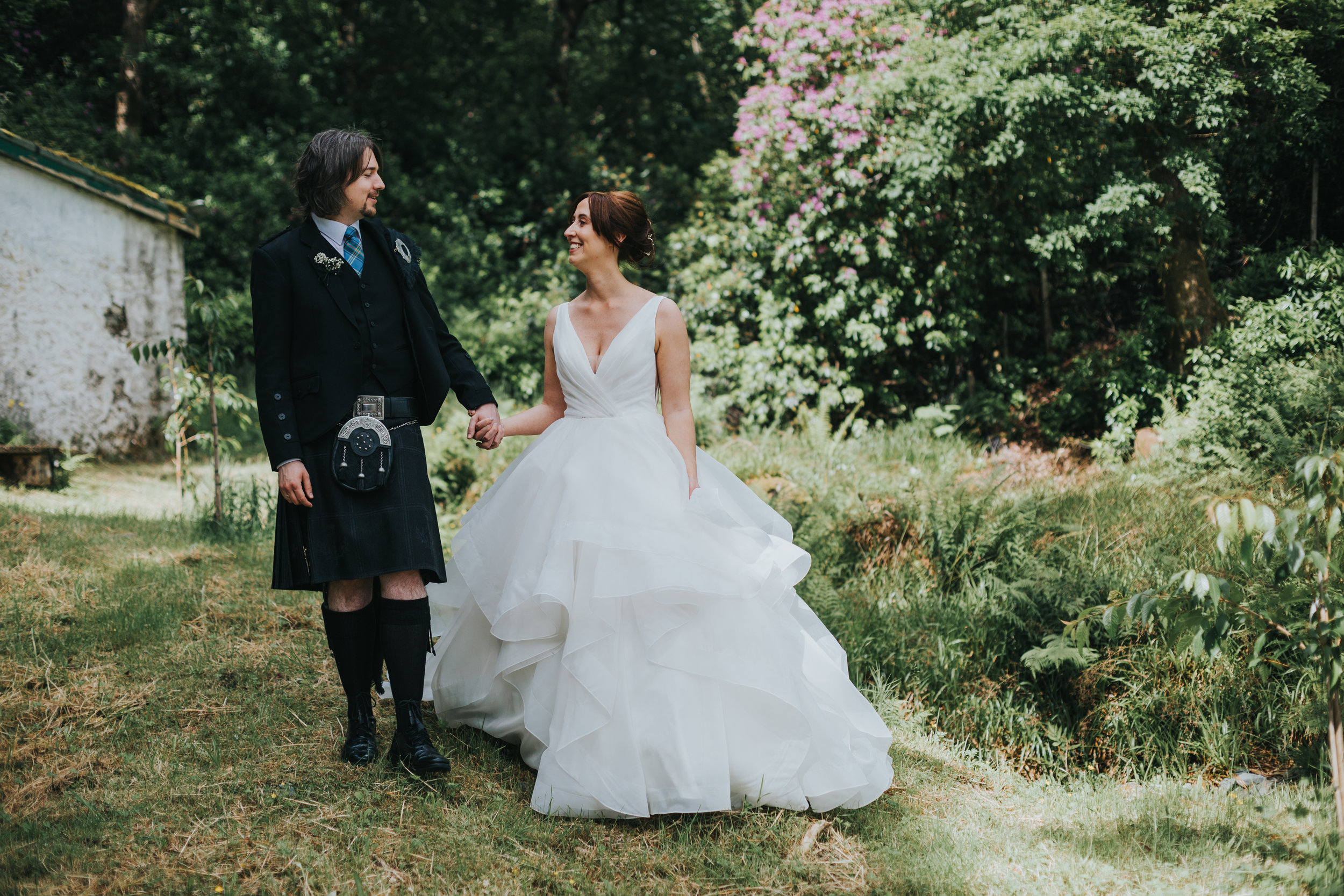 Bride and groom look at each other smiling.