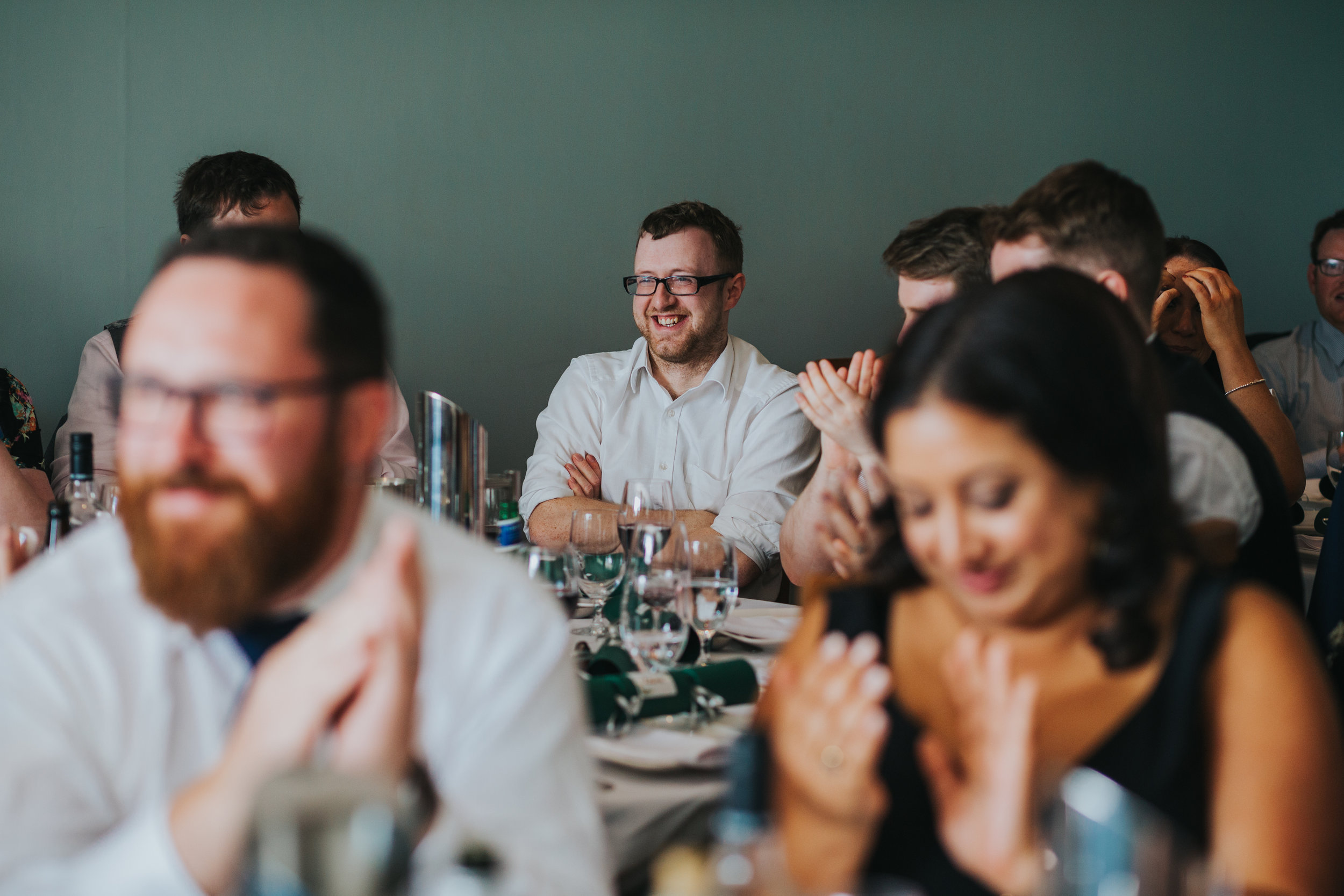 Wedding guests smiles as he is thanked for his work on the table plan. 