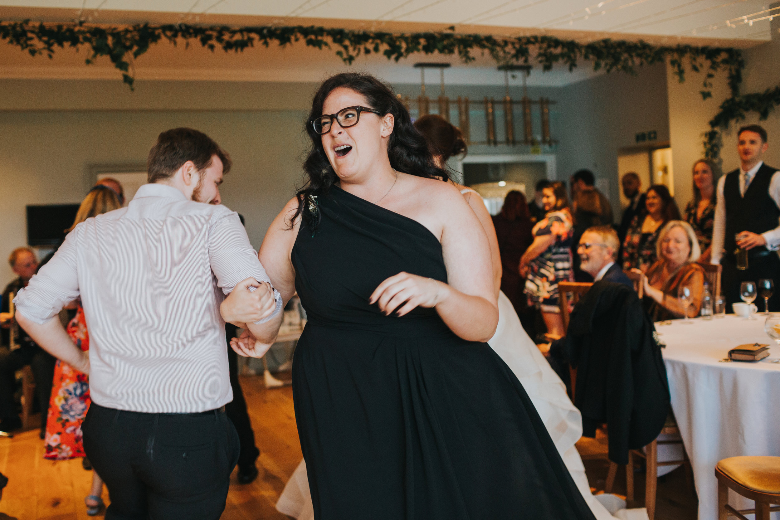 Wedding guest pulls funny face while dancing.