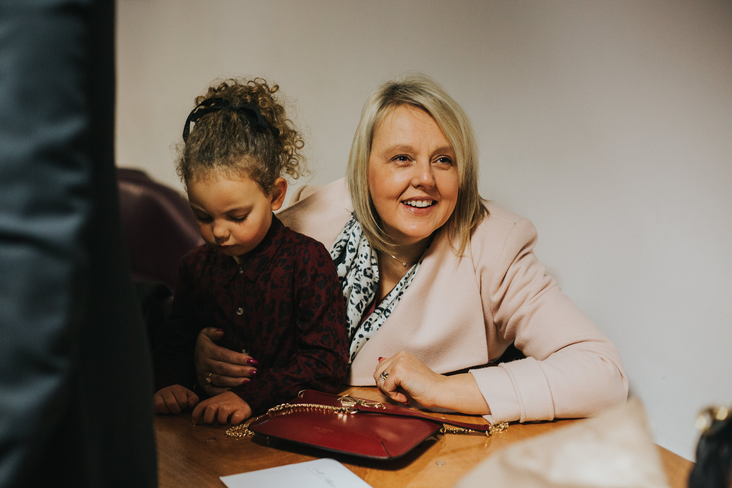 Lady smiles with little girl sitting on her lap.  (Copy)