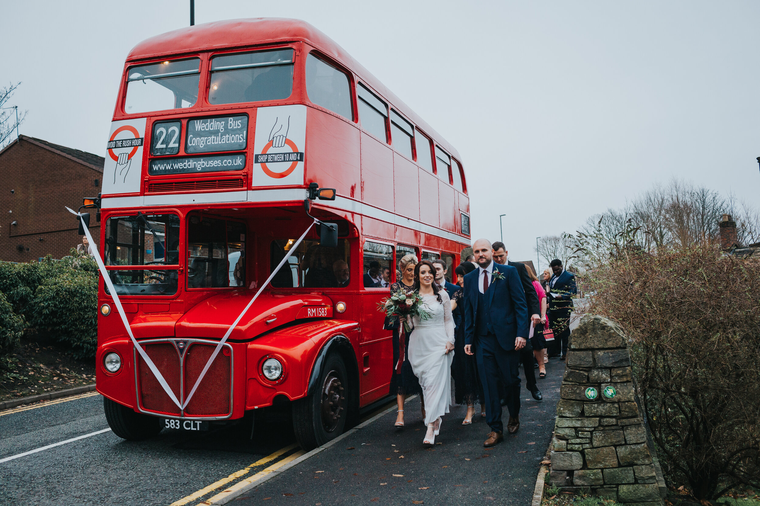 Bride and groom lead guests off the bus. 