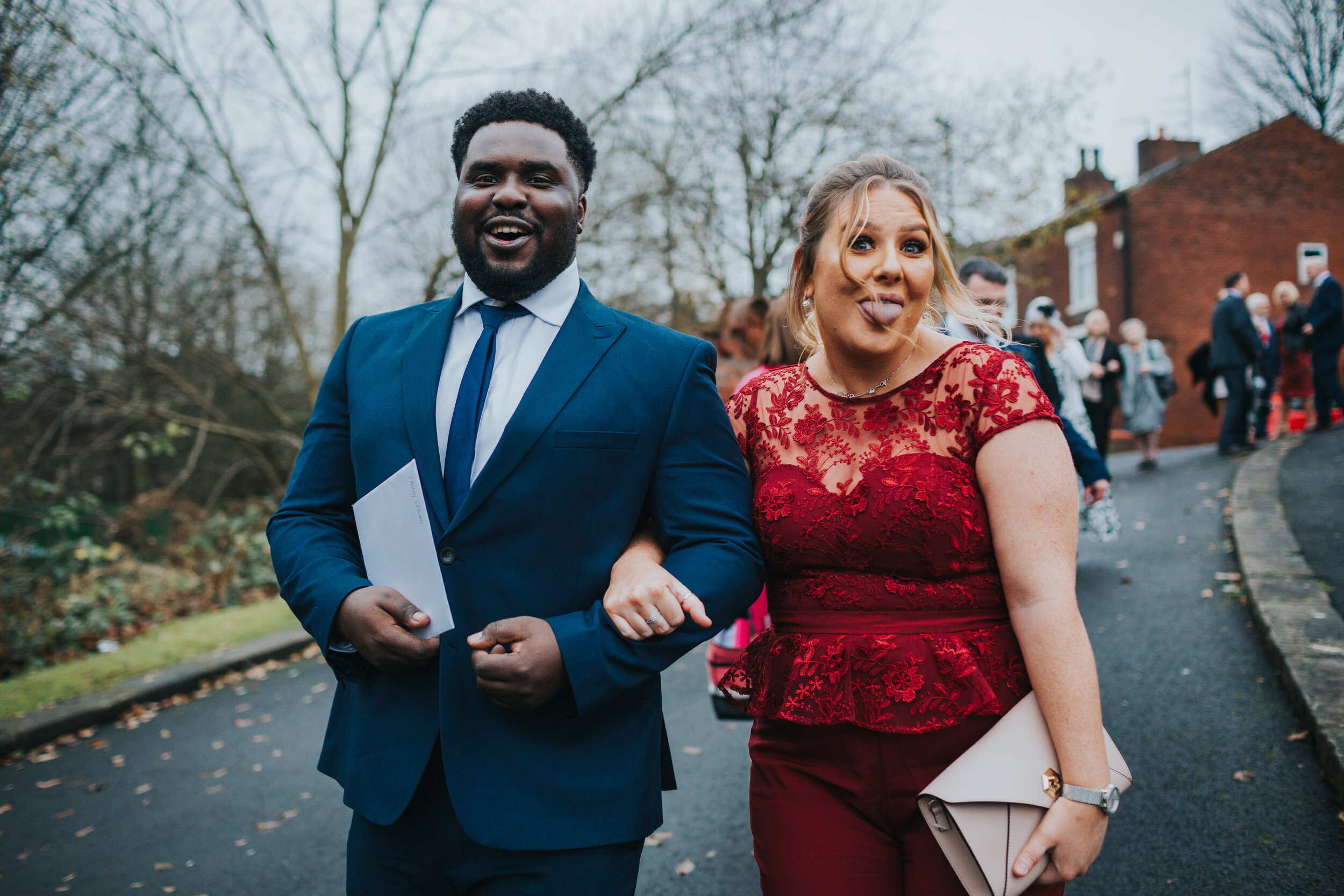 Wedding guests laughing and pulling tongues at the camera. 