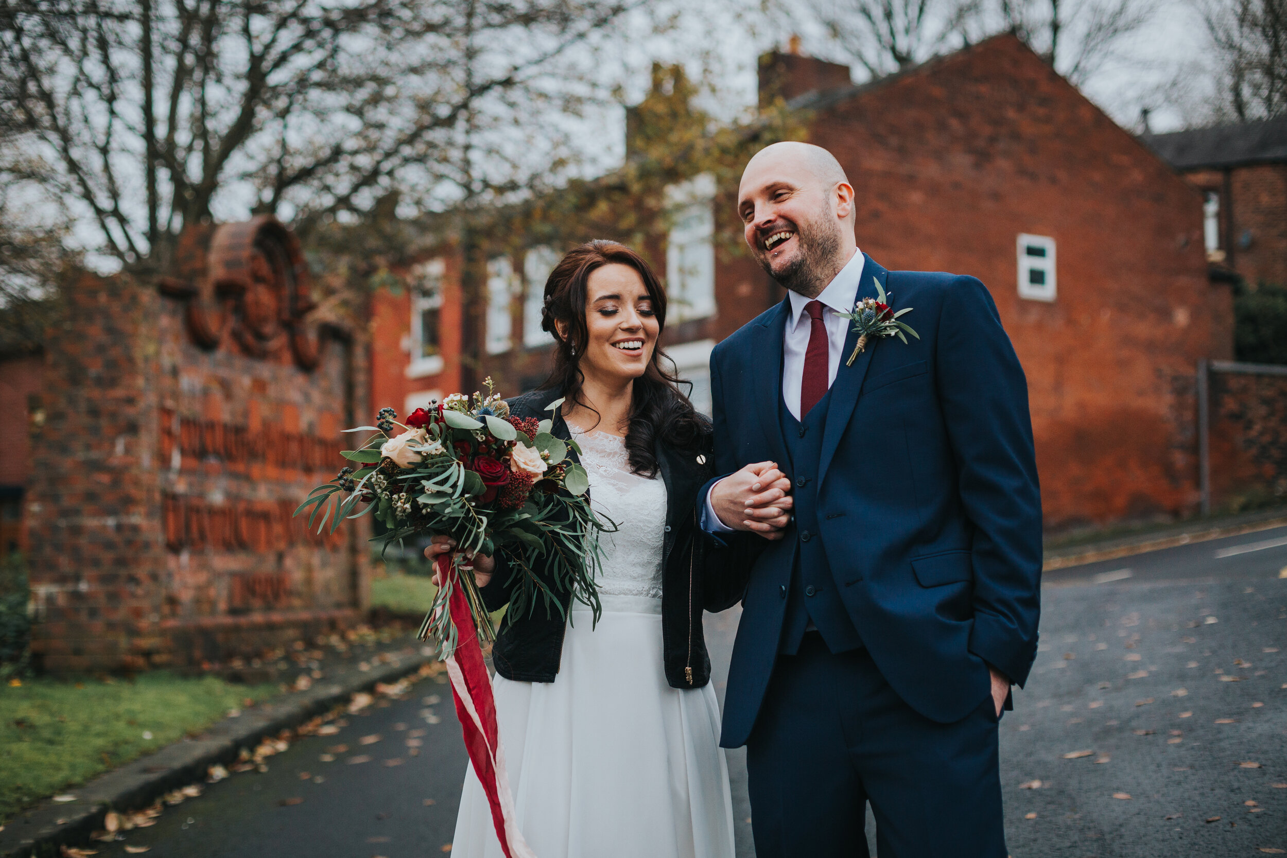 Bride and Groom mess around outside The Old Grammar School Middleton on a winters day. 