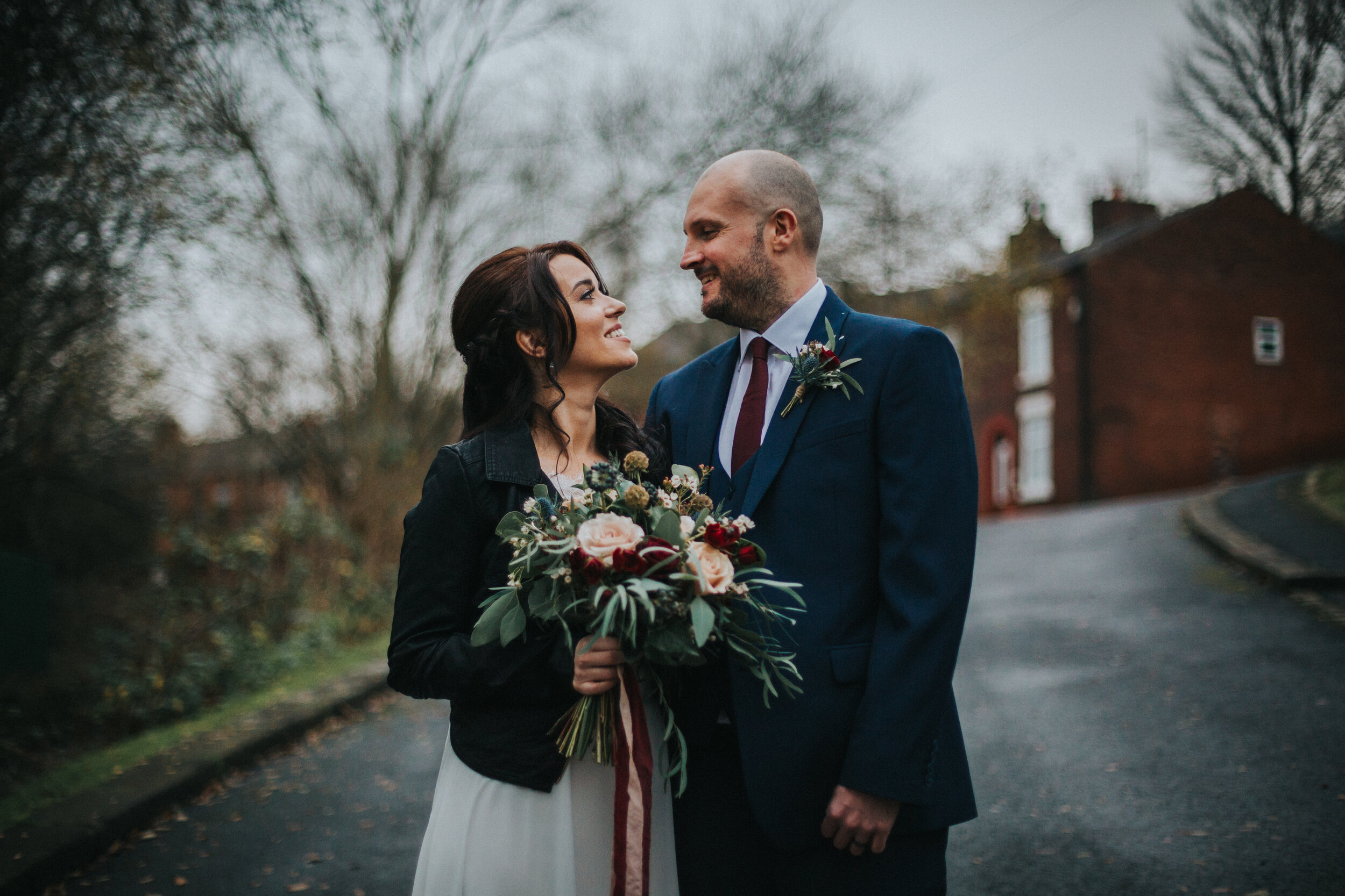 Bride and groom look at one another outside The Old Grammar School. 