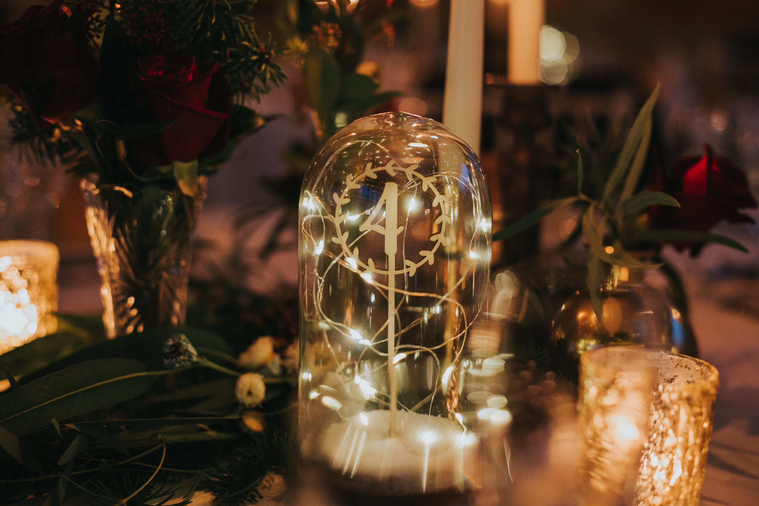 Table number is glass casing and wrapped in fairy lights. 