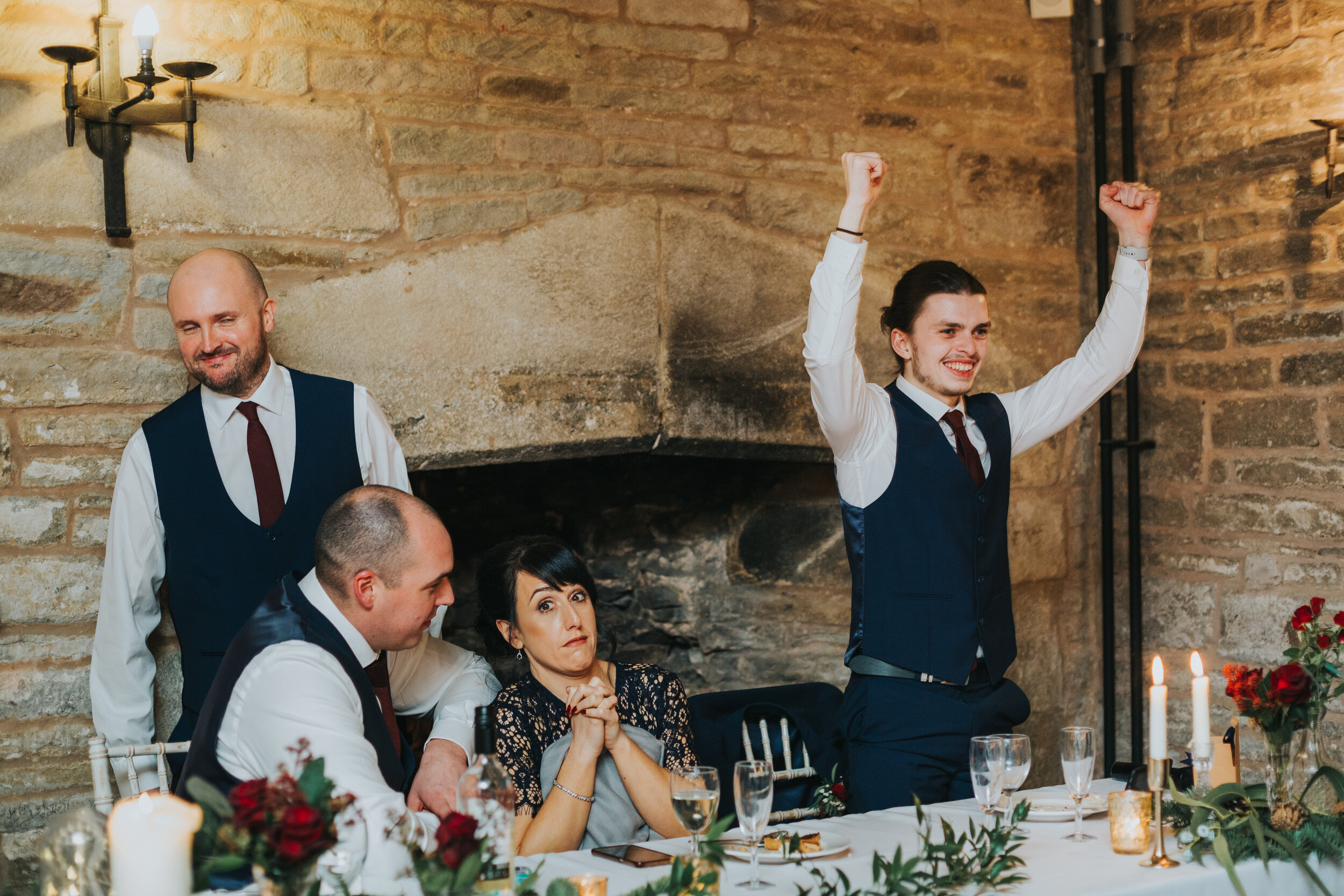 Brother of the bride cheers while bridesmaid looks shocked. 