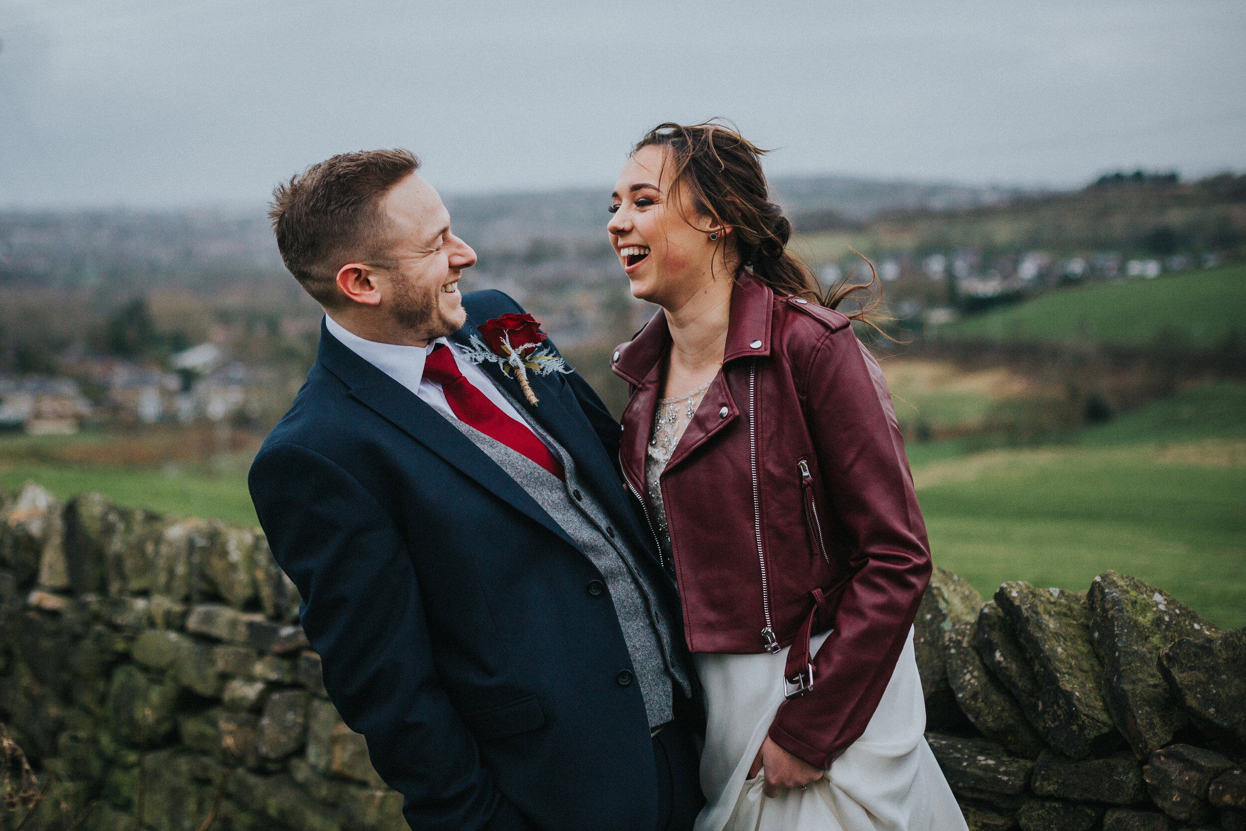 Bride and Groom laugh with wind swept hair. 