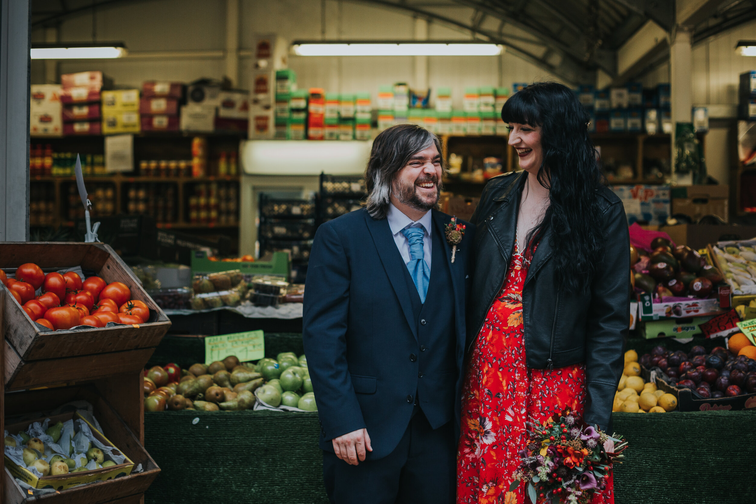 Mid shot of the Bride and Groom laughing outside a vegetable stall in Manchester City Centre. (Copy)