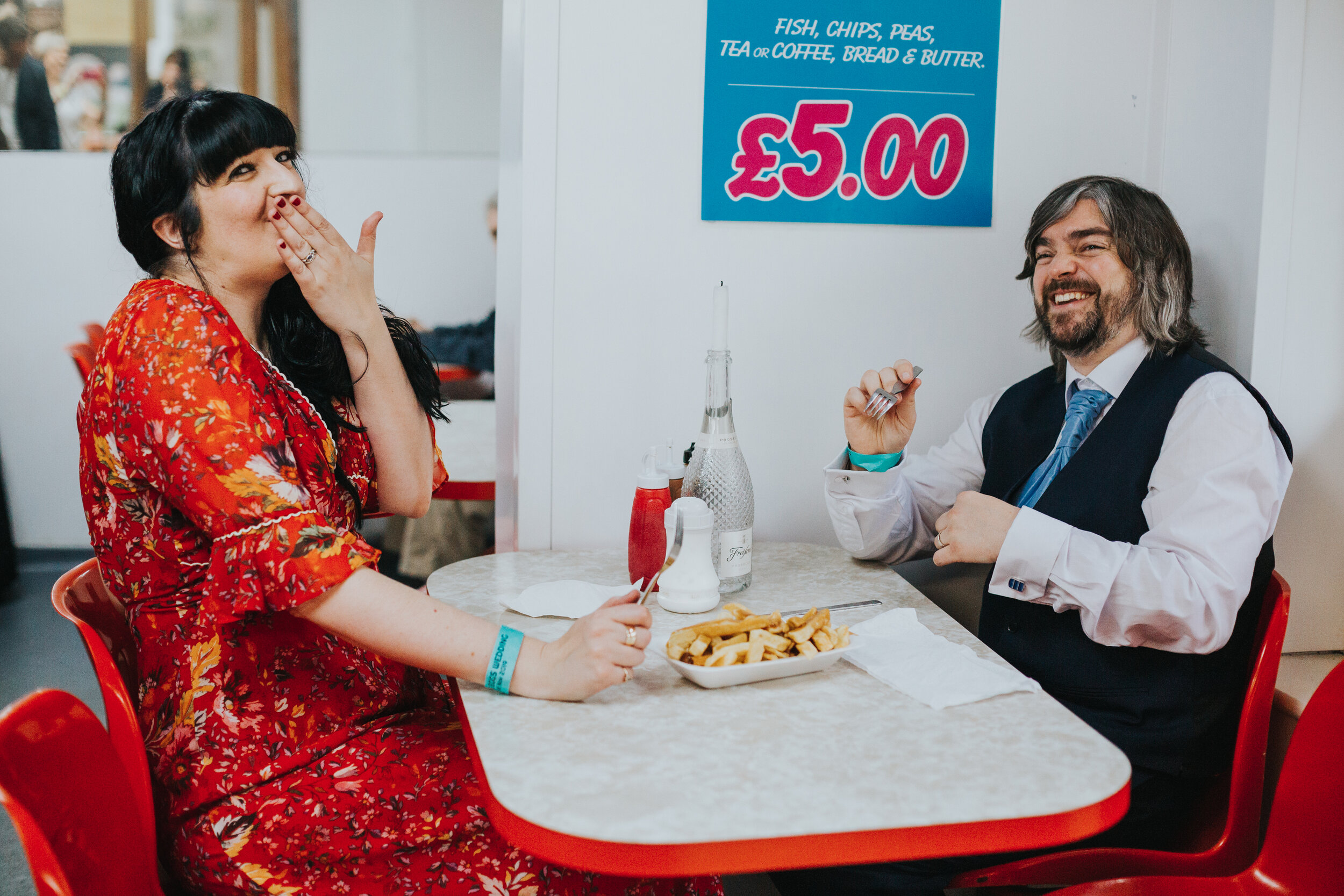 Bride and groom giggle as they eat their chips.   (Copy)