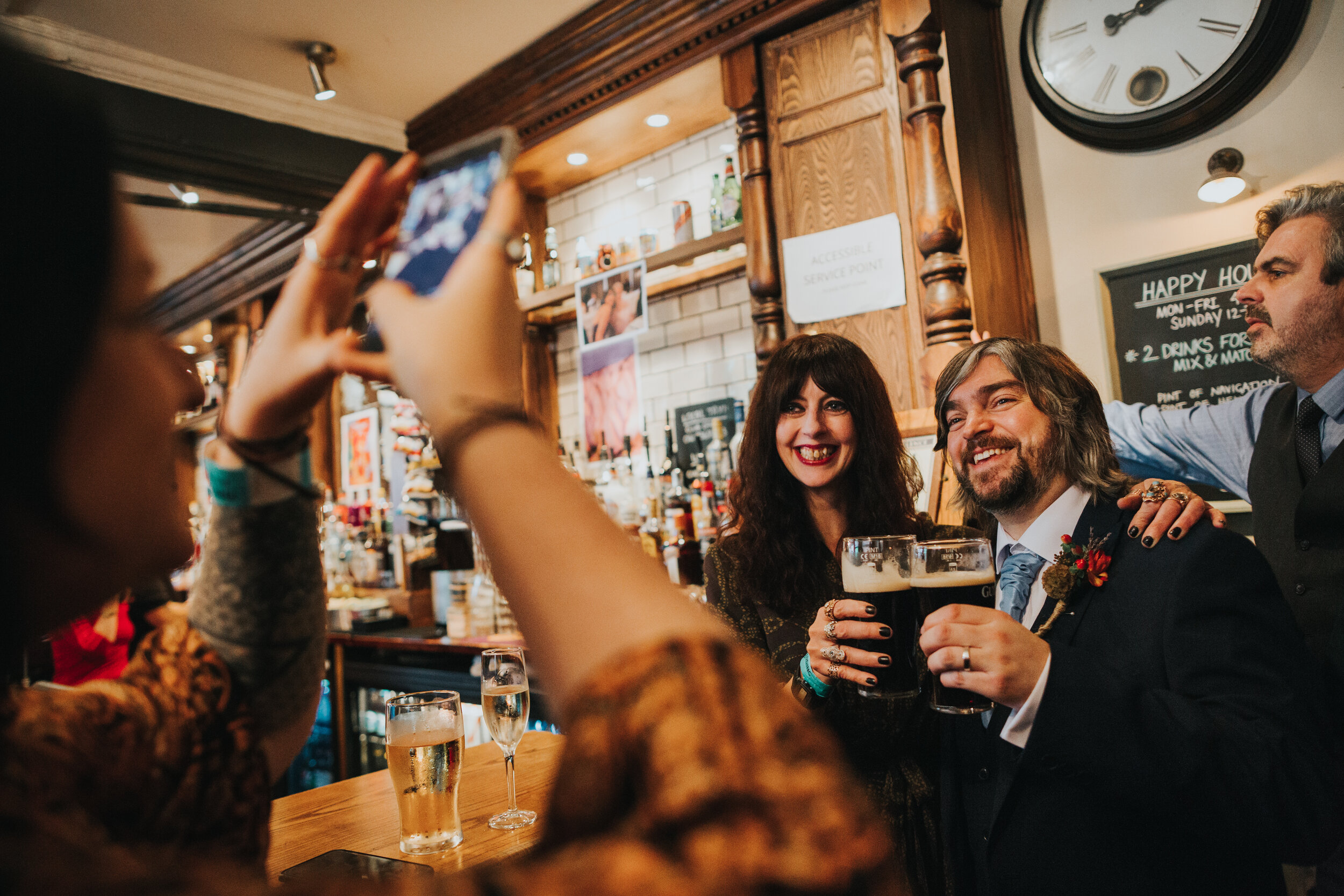 Wedding guests take photo of groom and other guest.  (Copy)