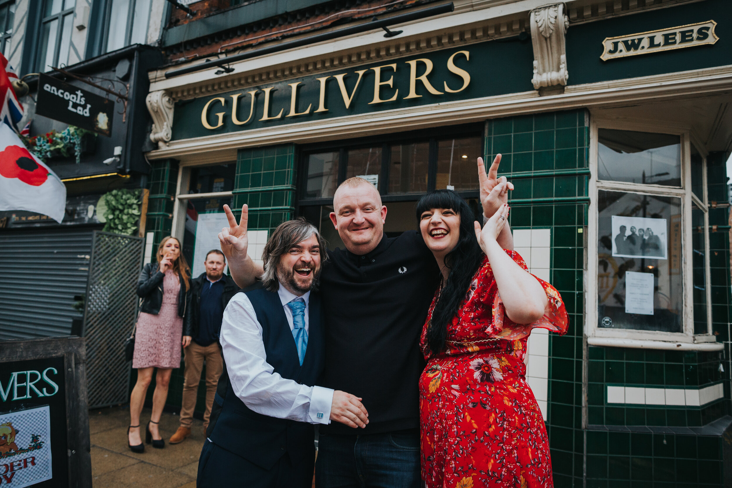 Bride and Groom pose with wedding guest outside pub in Manchester.  (Copy)