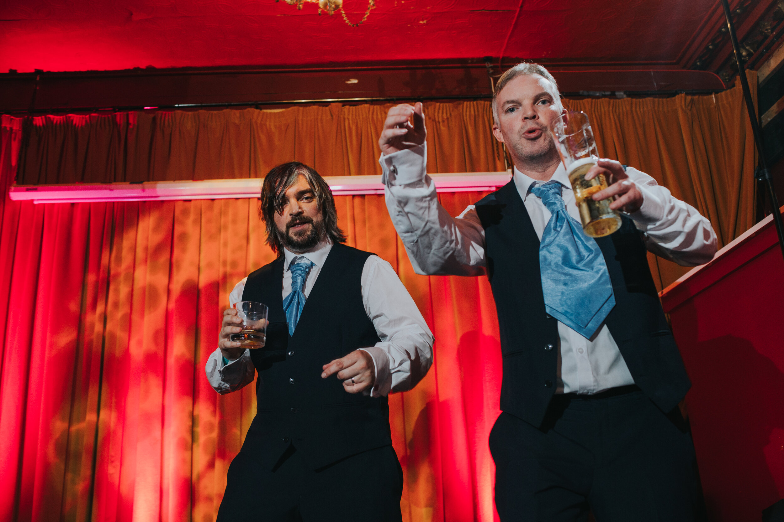 Groom and best man dance on the stage.  (Copy)