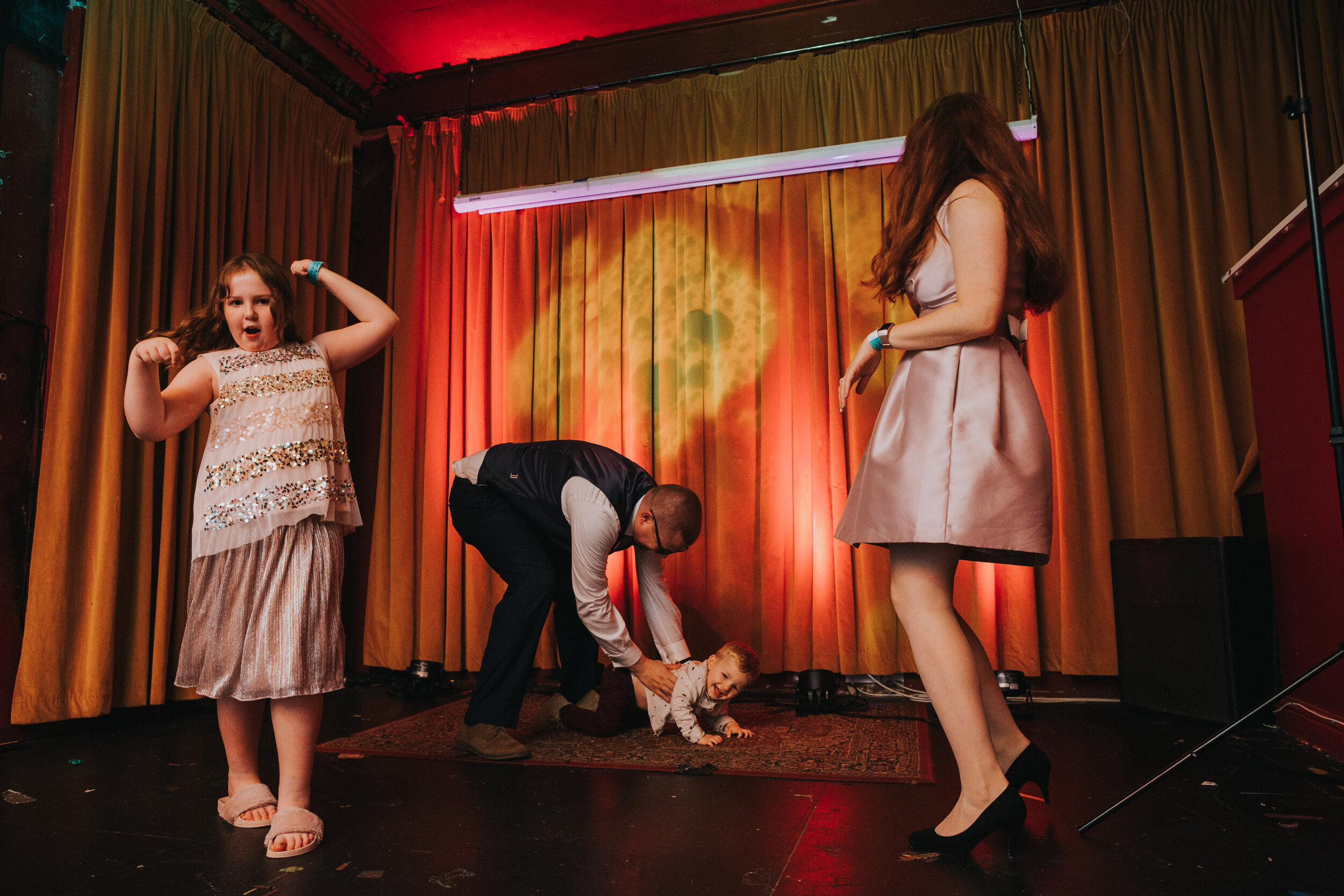 Little boy crawling on the the stage as guests dance around.  (Copy)