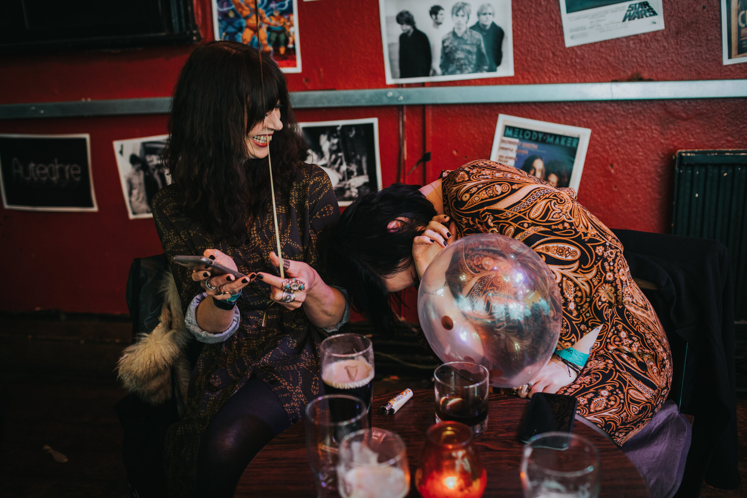 Wedding guests laugh and one tried to hide behind a transparent balloon at Manchester pub wedding. (Copy)