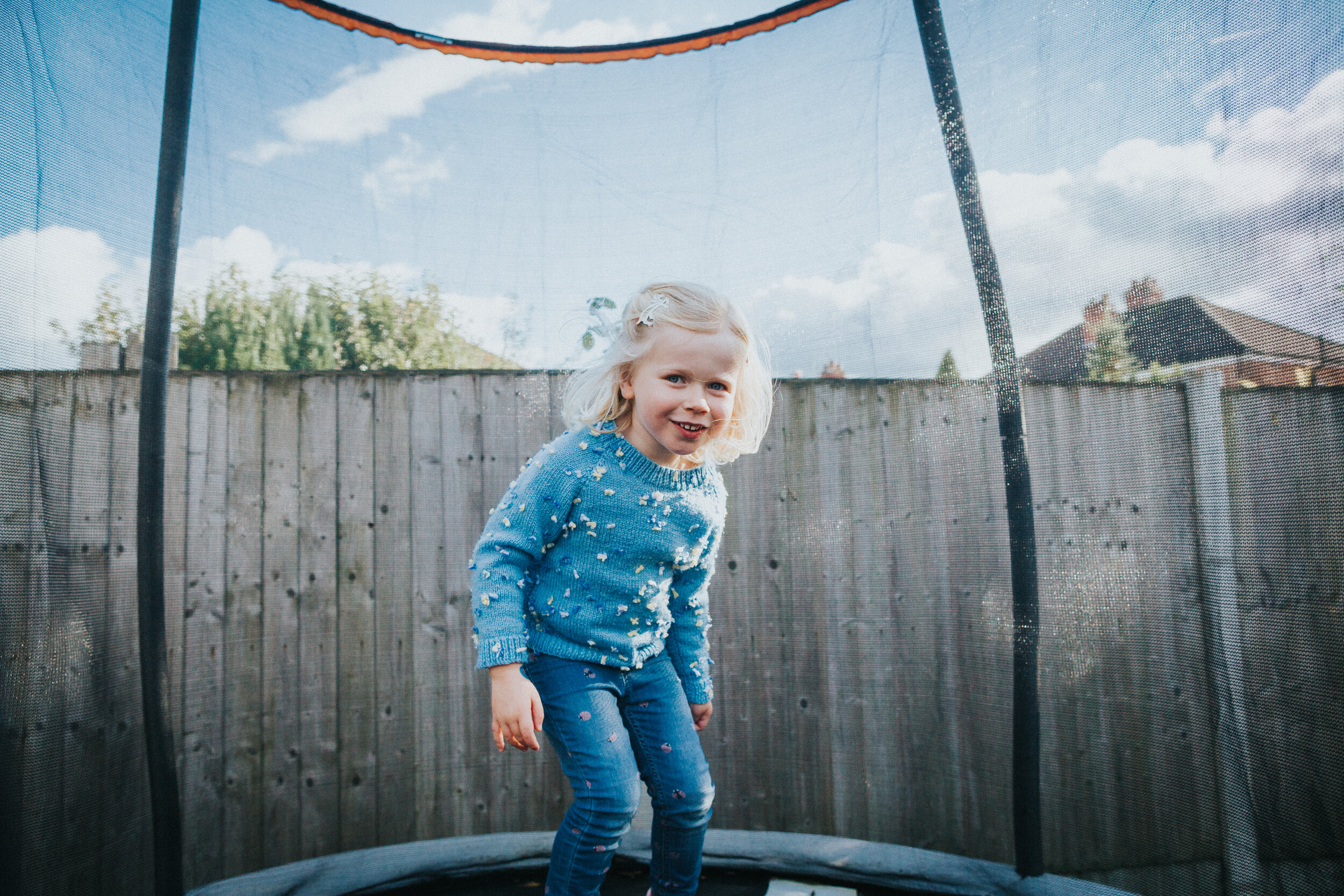 Little girl smile and she plays on trampoline. 