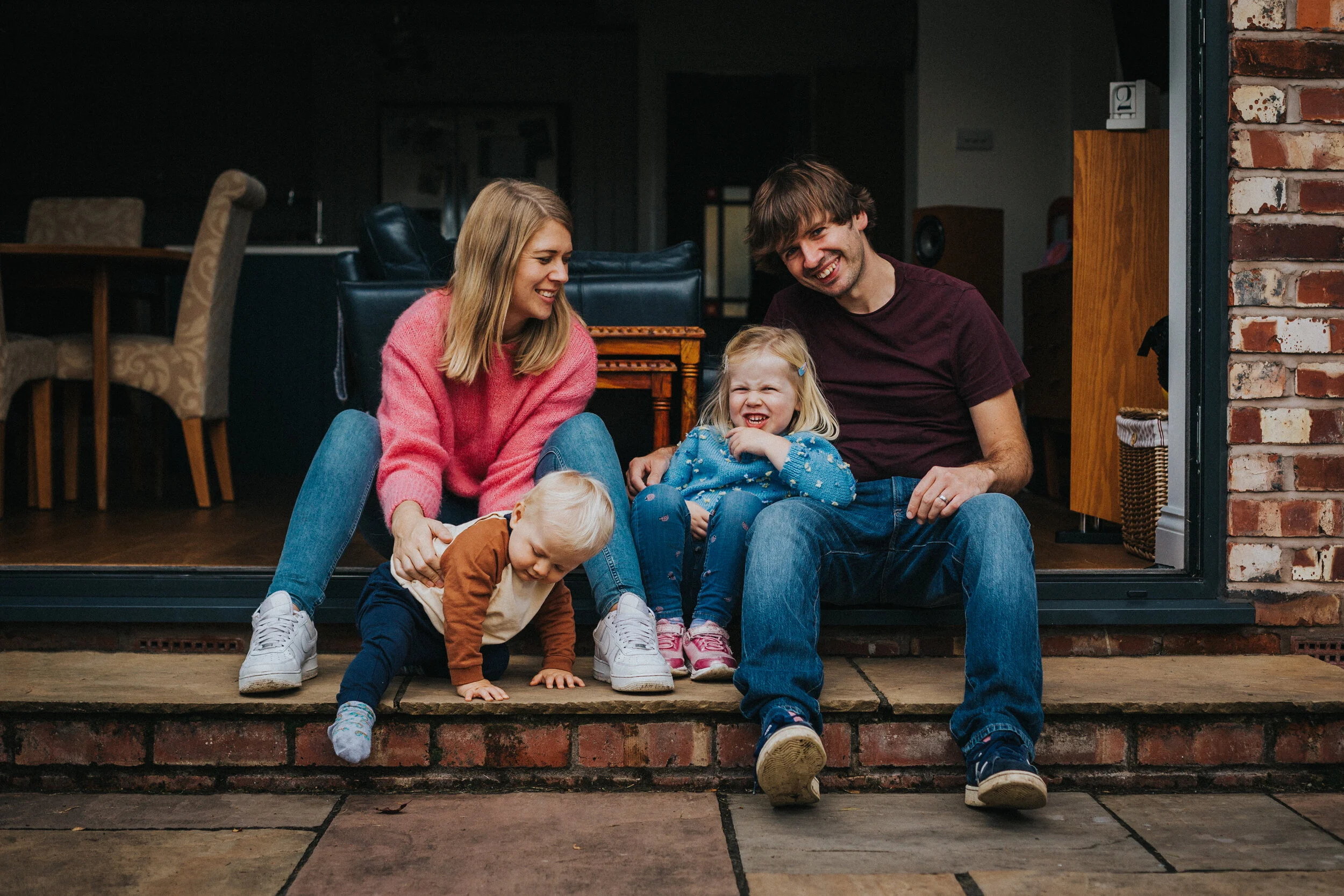 Family sit on the floor and have a laugh together. 