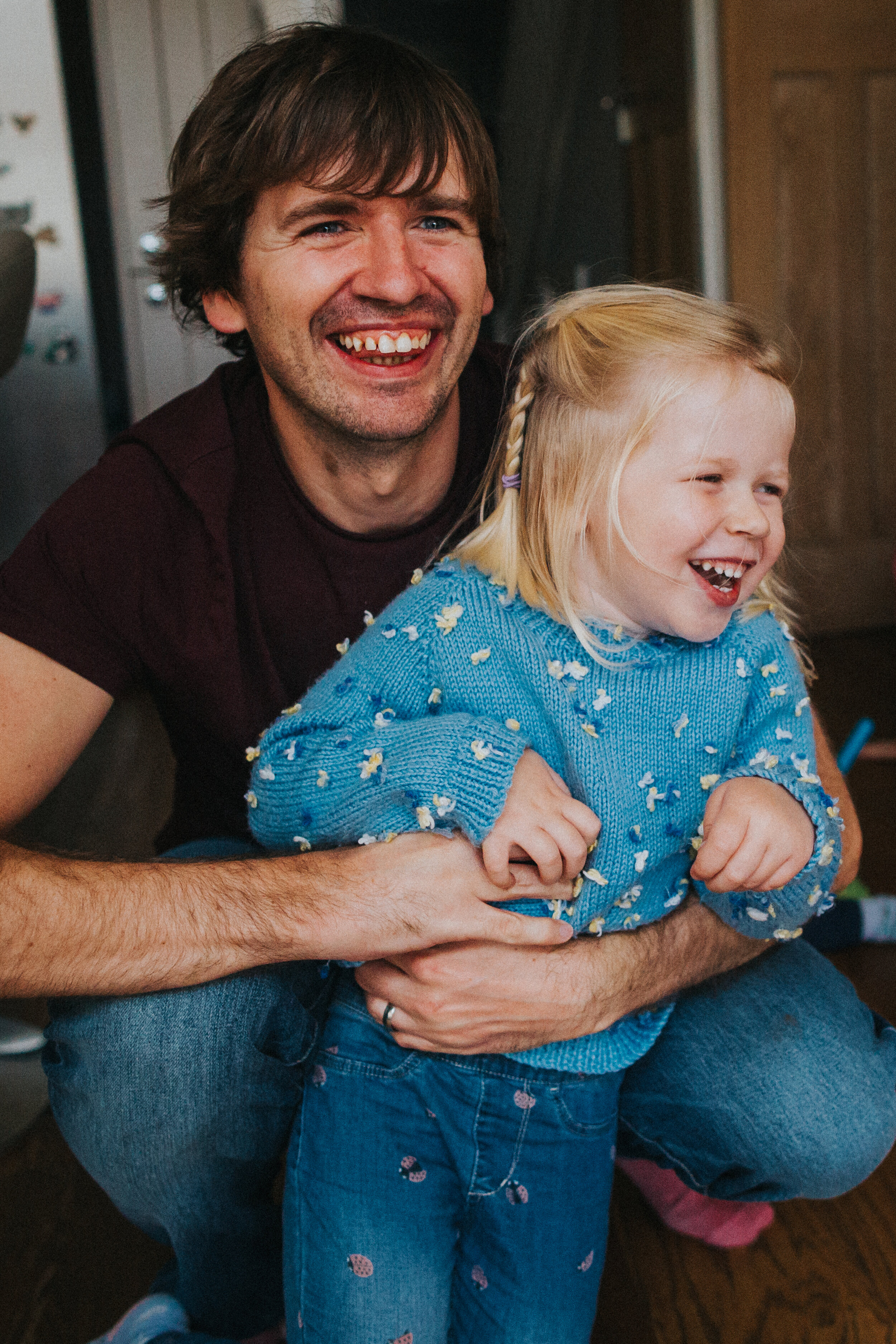 Dad and little girl laughing together.