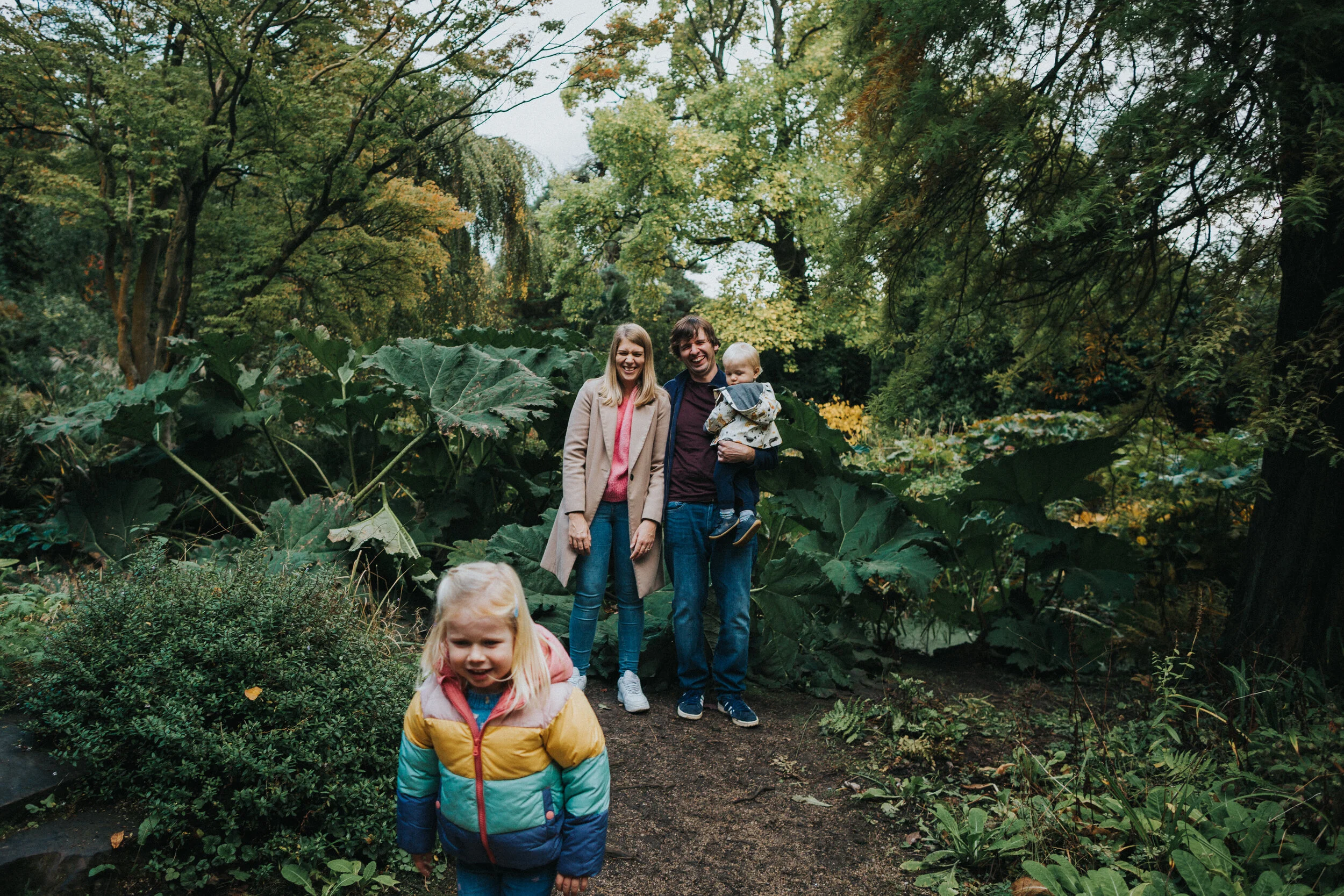 Little girls runs away from family laughing. 