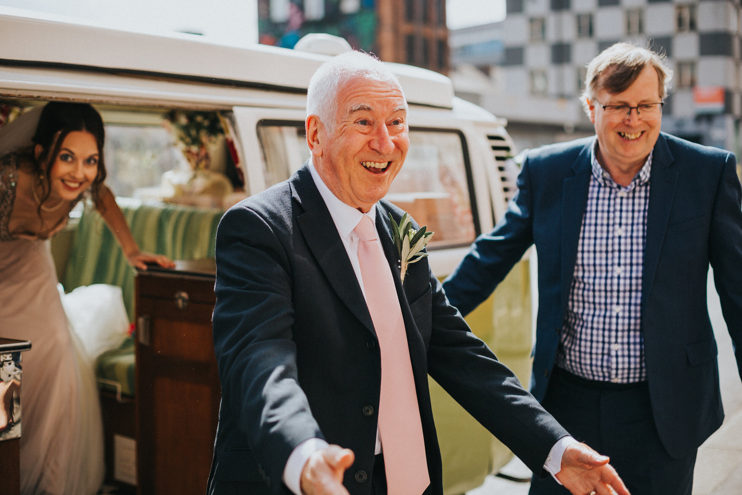 Father of the Bride exits VW camper van looking excited to see someone. 