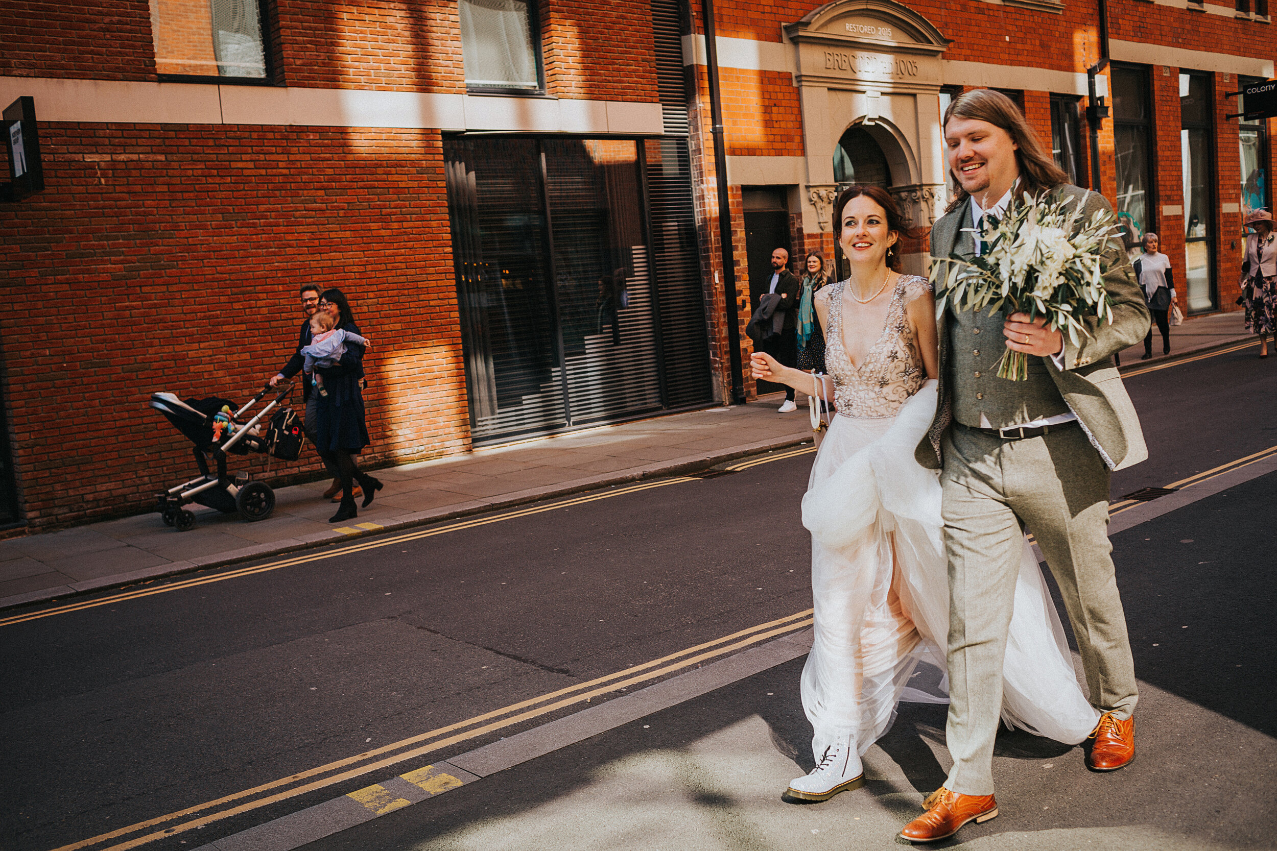 The couple walk with their wedding guests to have a picnic in Manchester City Centre.