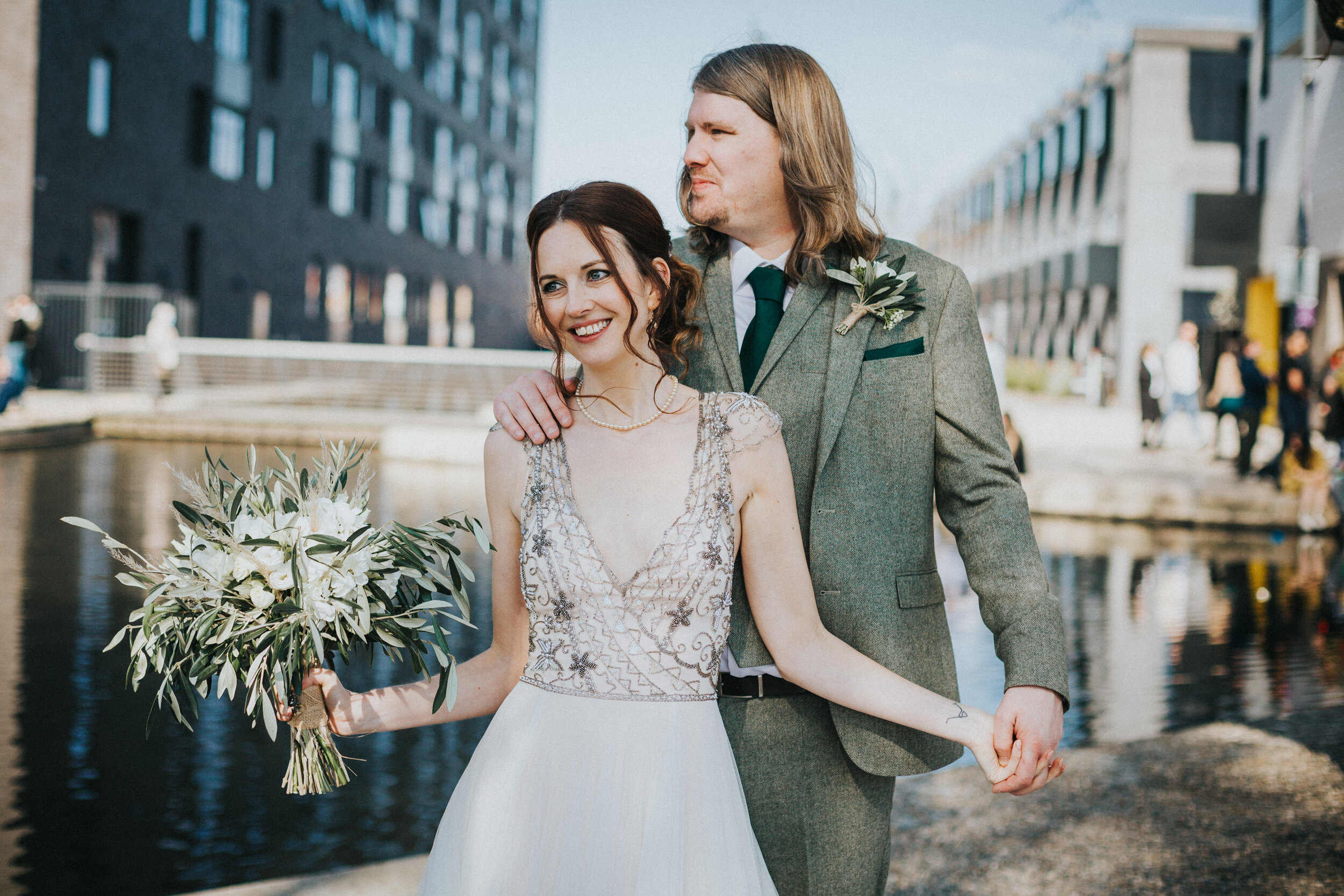 Bride and Groom stand in front of the canal together. 