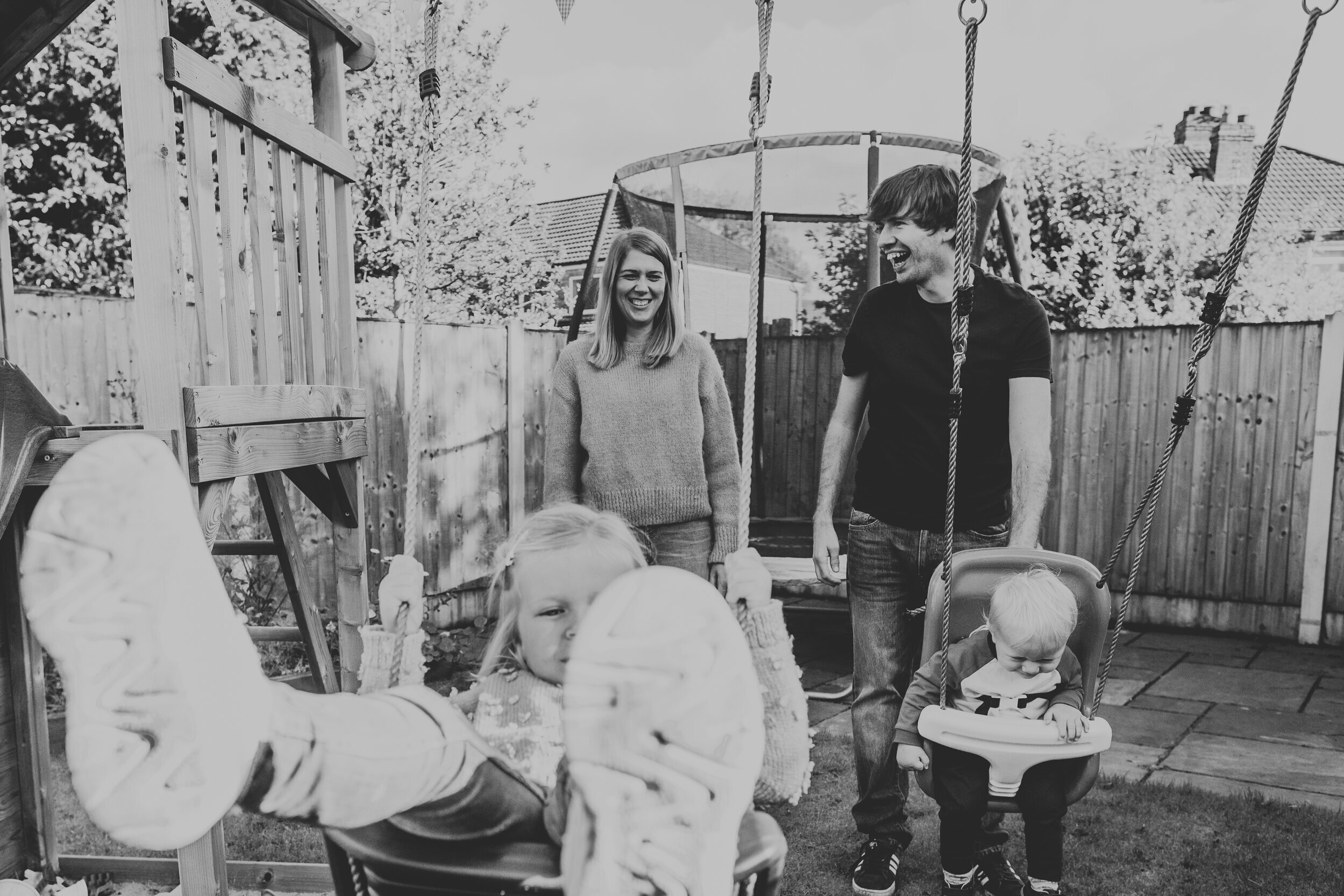 Mum and Dad push their children on swings at their family home in South Manchester