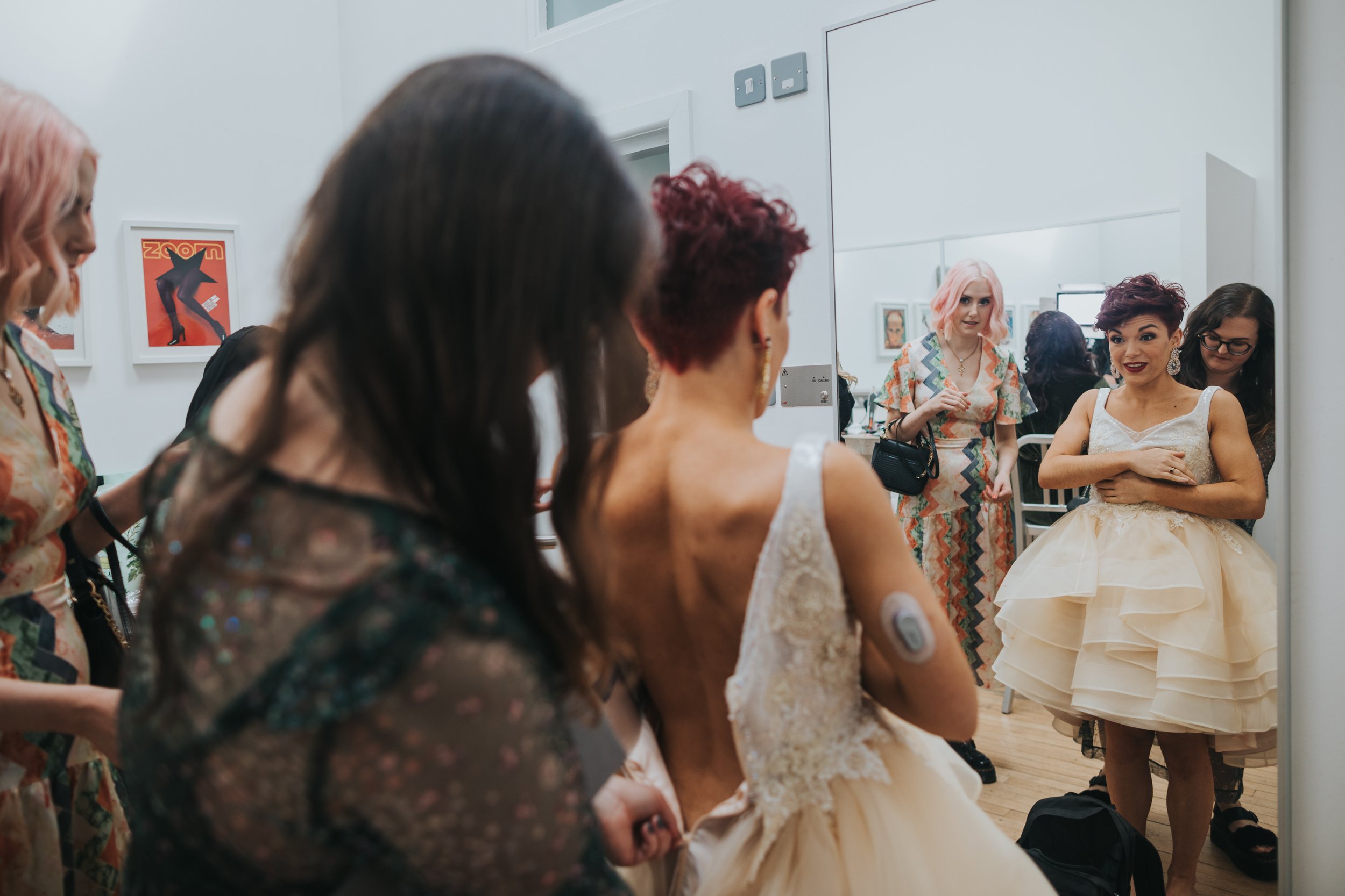 Bride looks at herself in the mirror smiling,