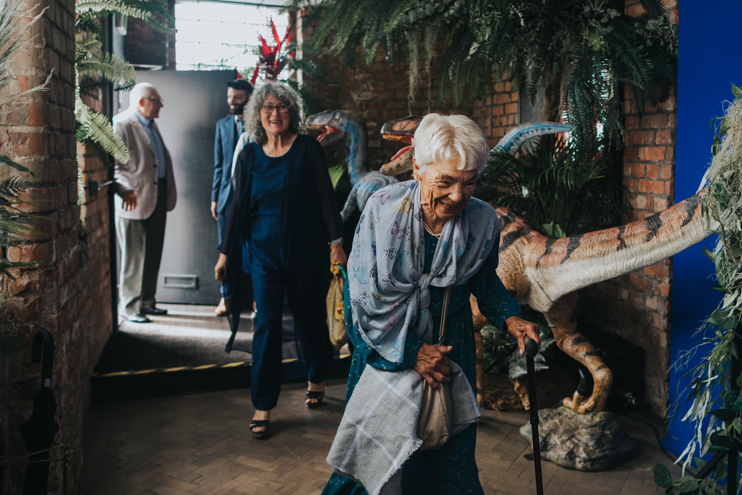 Wedding guests leg it through the dinosaur infested hall way. 