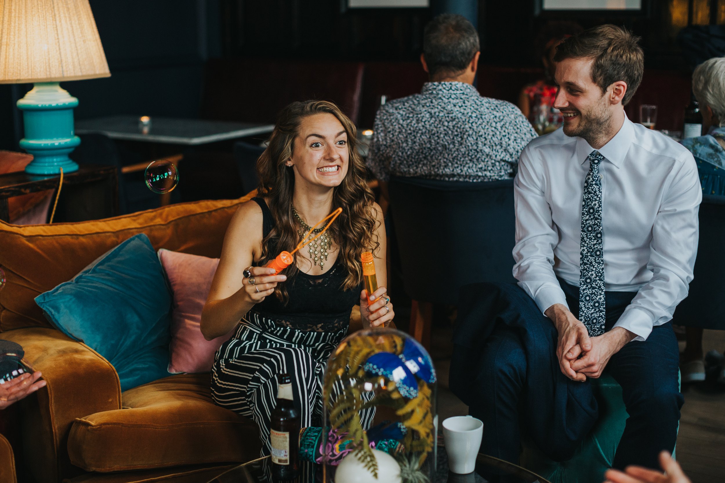 Guests sitting on the sofas chatting. 