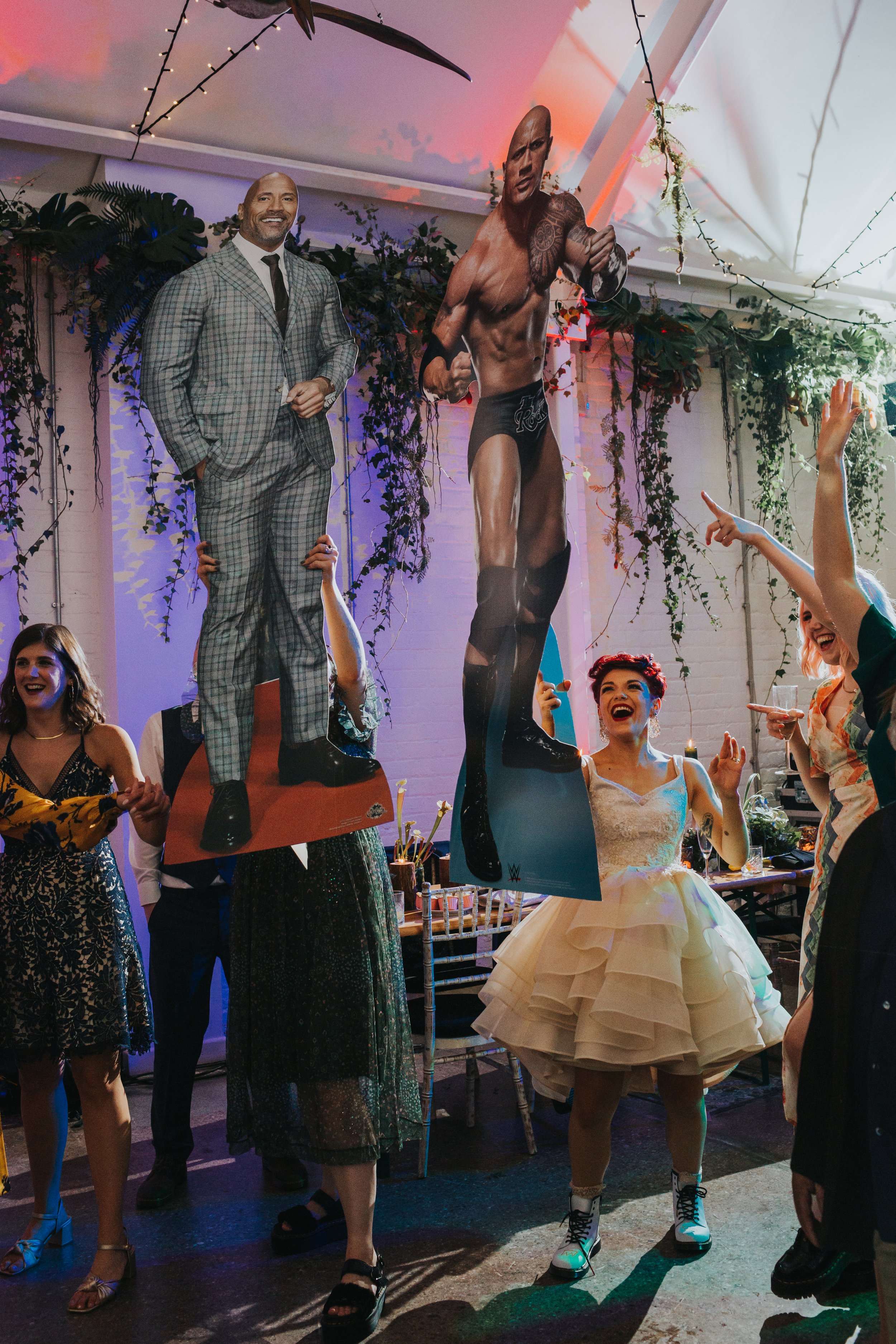 Bride and guests holding up card board cut out guests and dancing with them. 