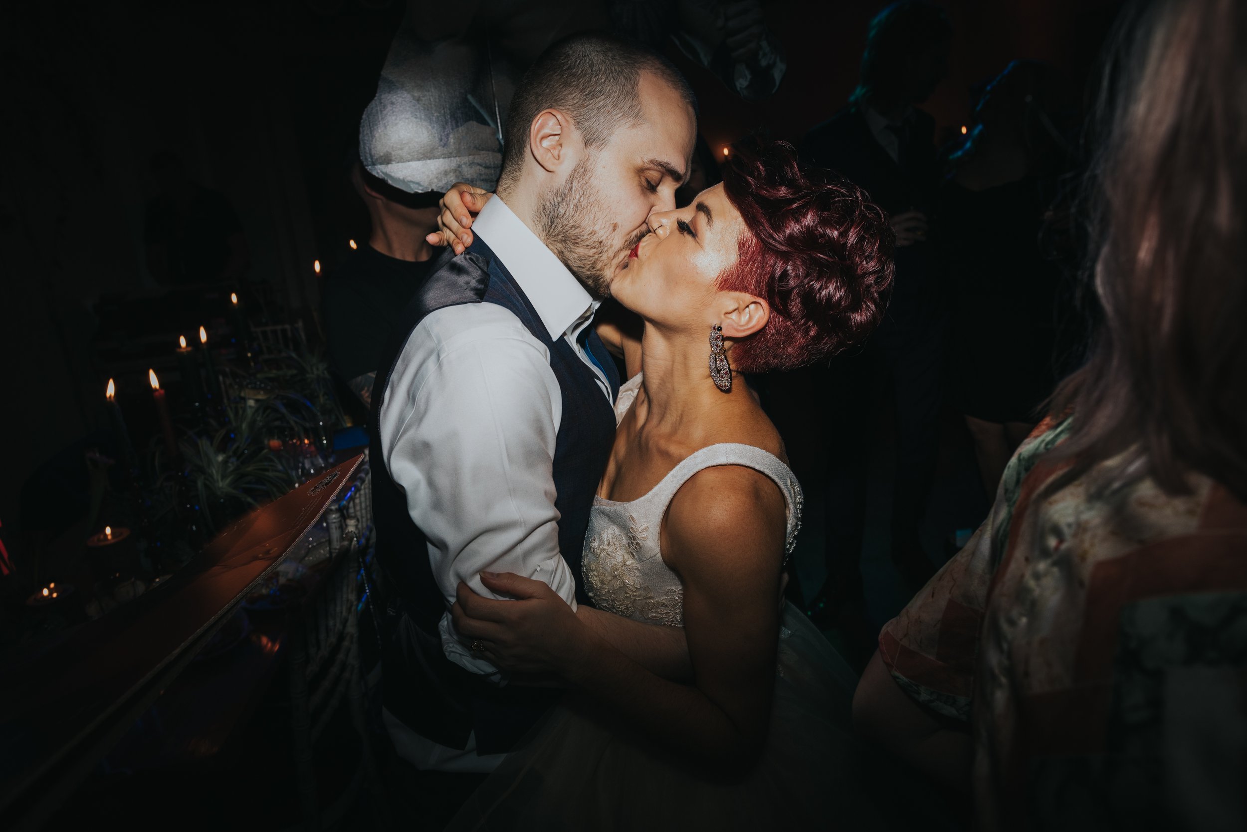 Bride and groom kiss on the dance floor. 