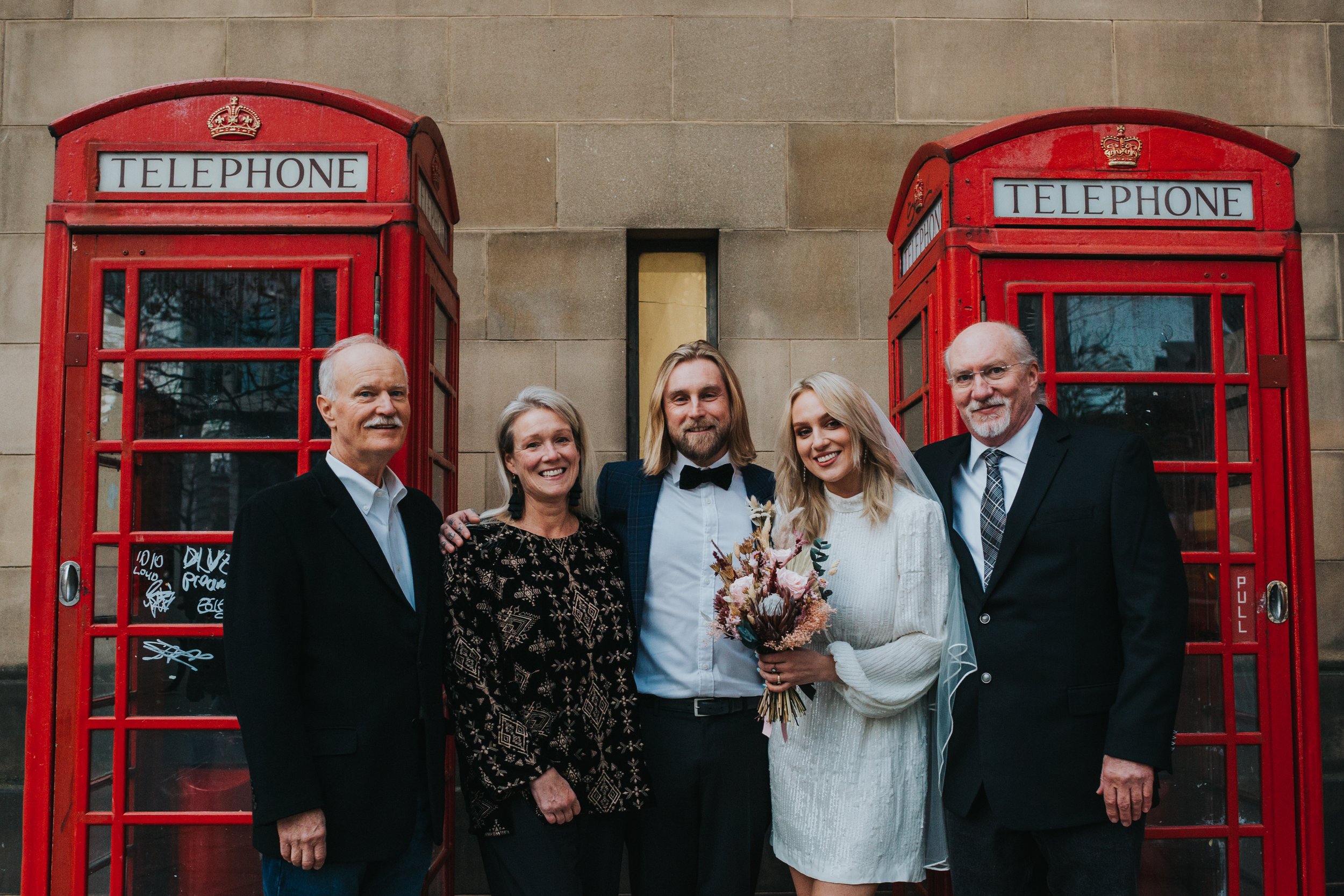 Family photo in front of the red phone boxes. 