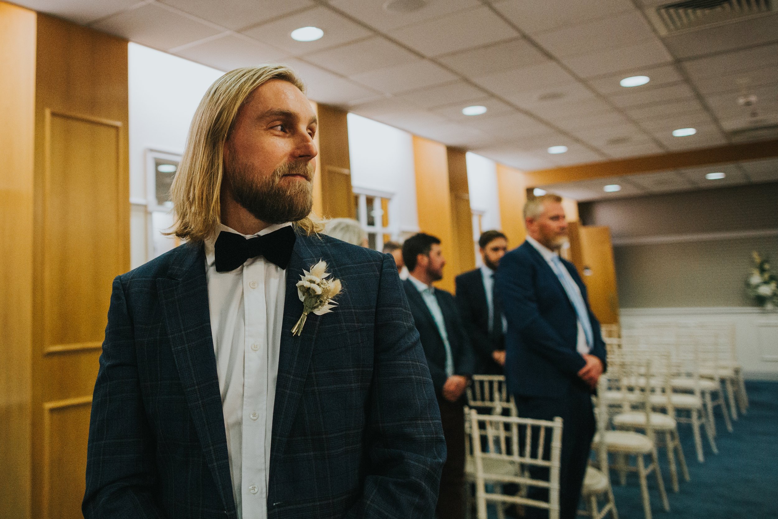 Groom stands as his bride enters the ceremony room.