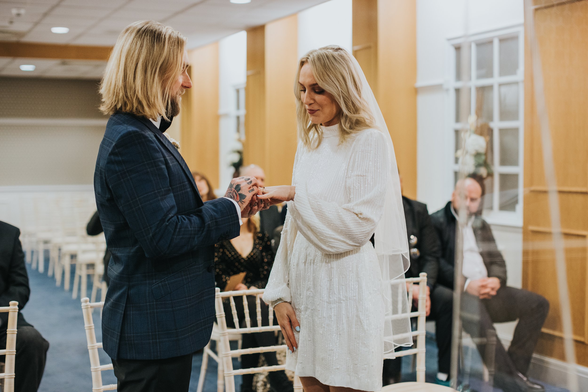 Groom puts the ring on the brides finger. 