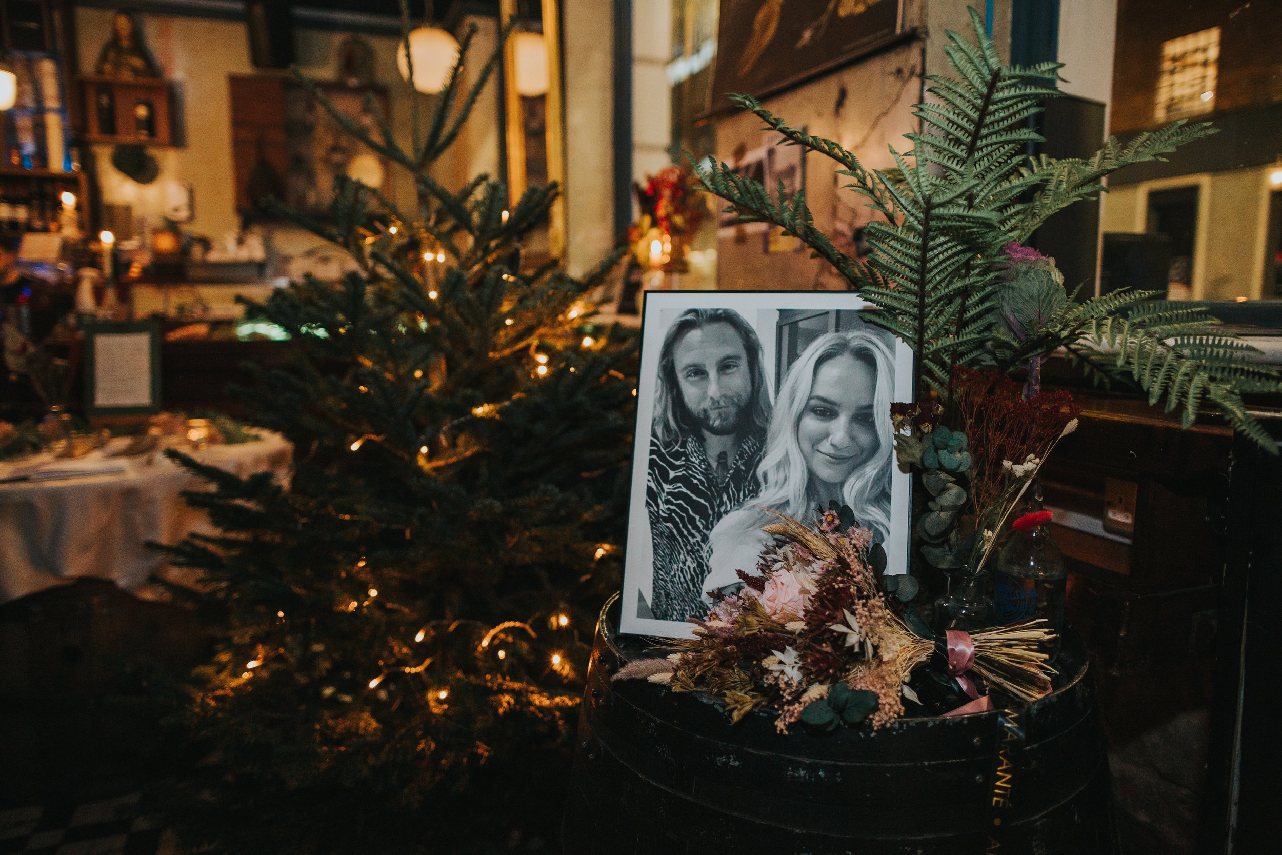 Photo of bride and groom next to Christmas tree in Flok Manchester. 