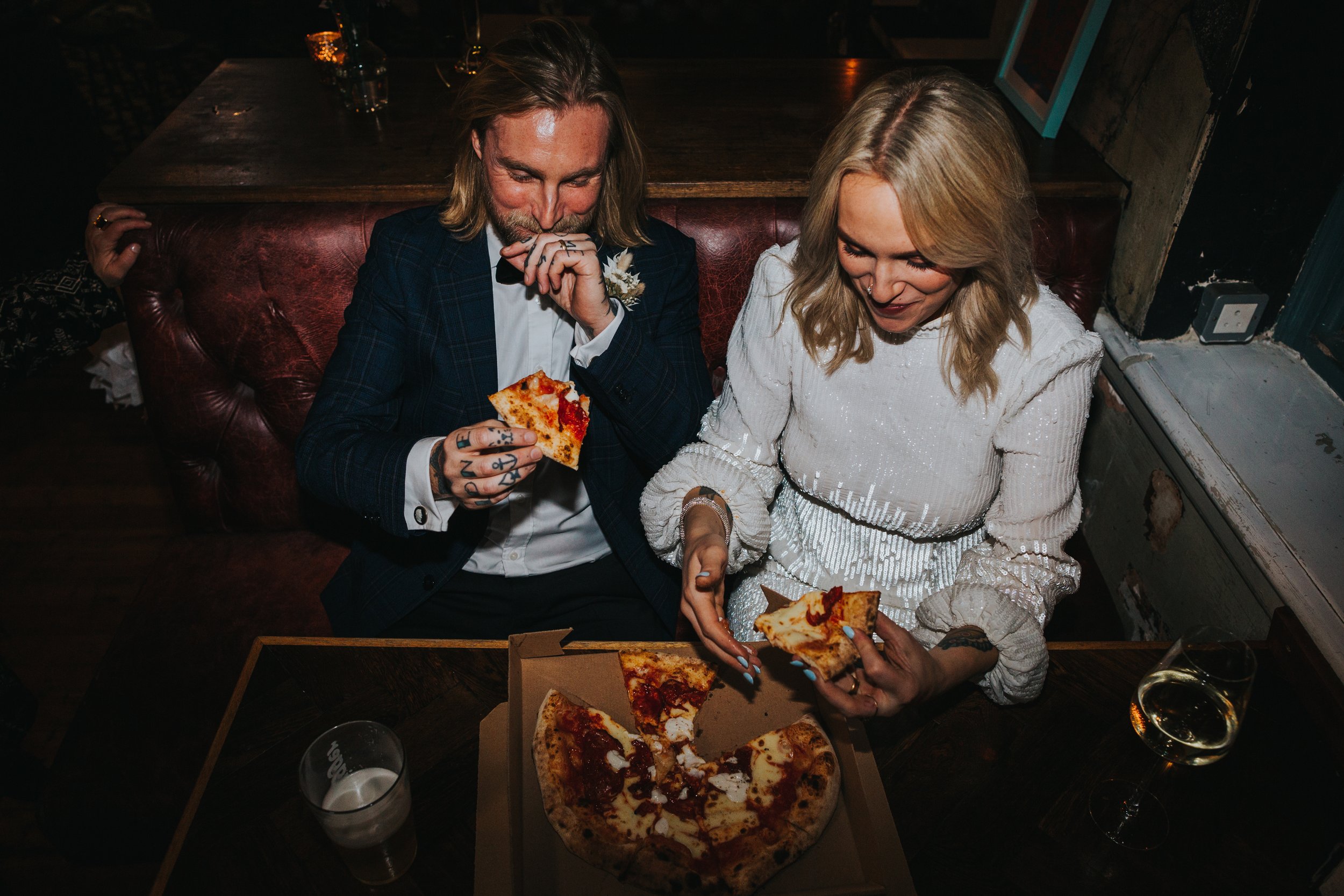 Couple eating pizza and laughing shot from above. 