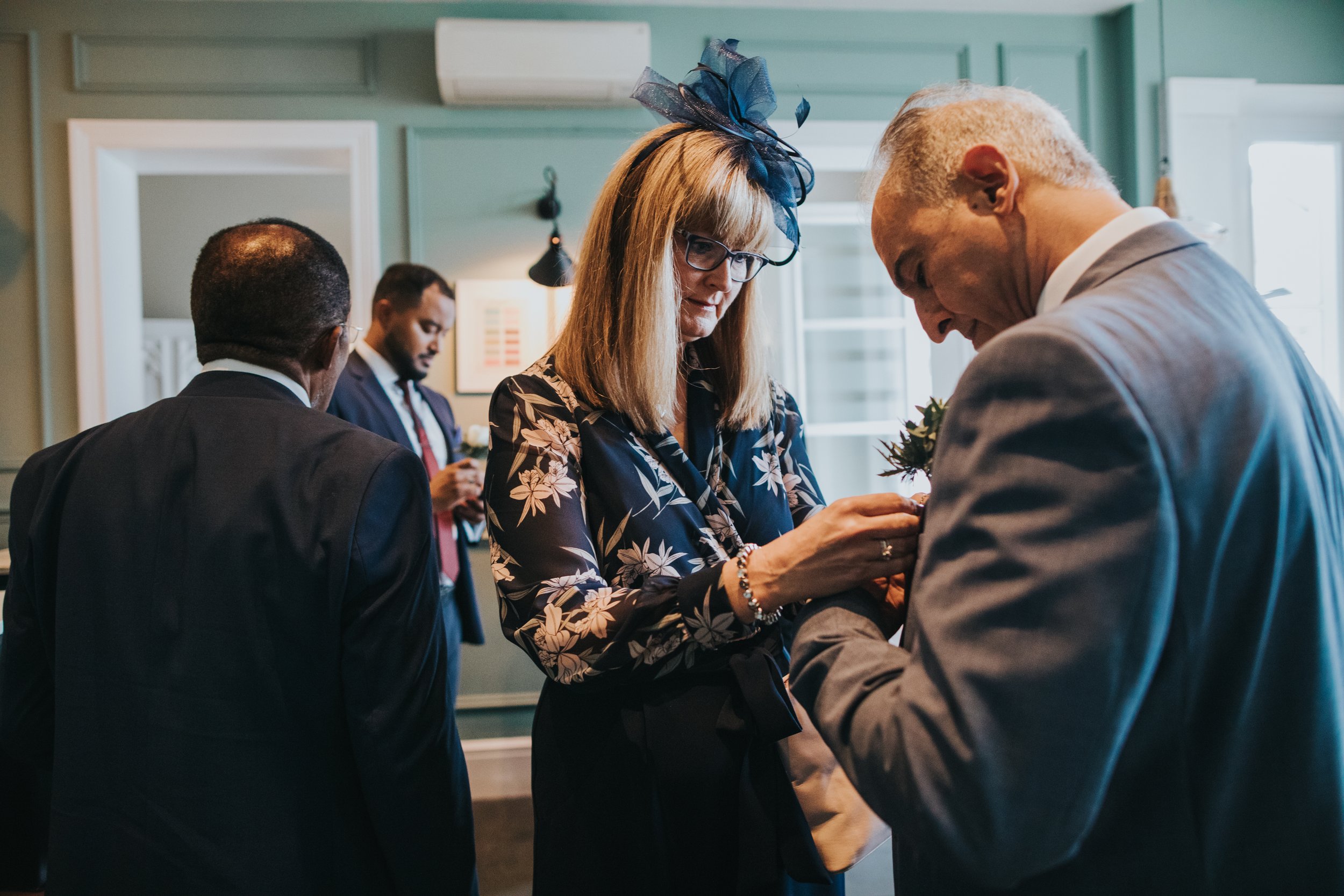 Father of the bride has help with his button hole.