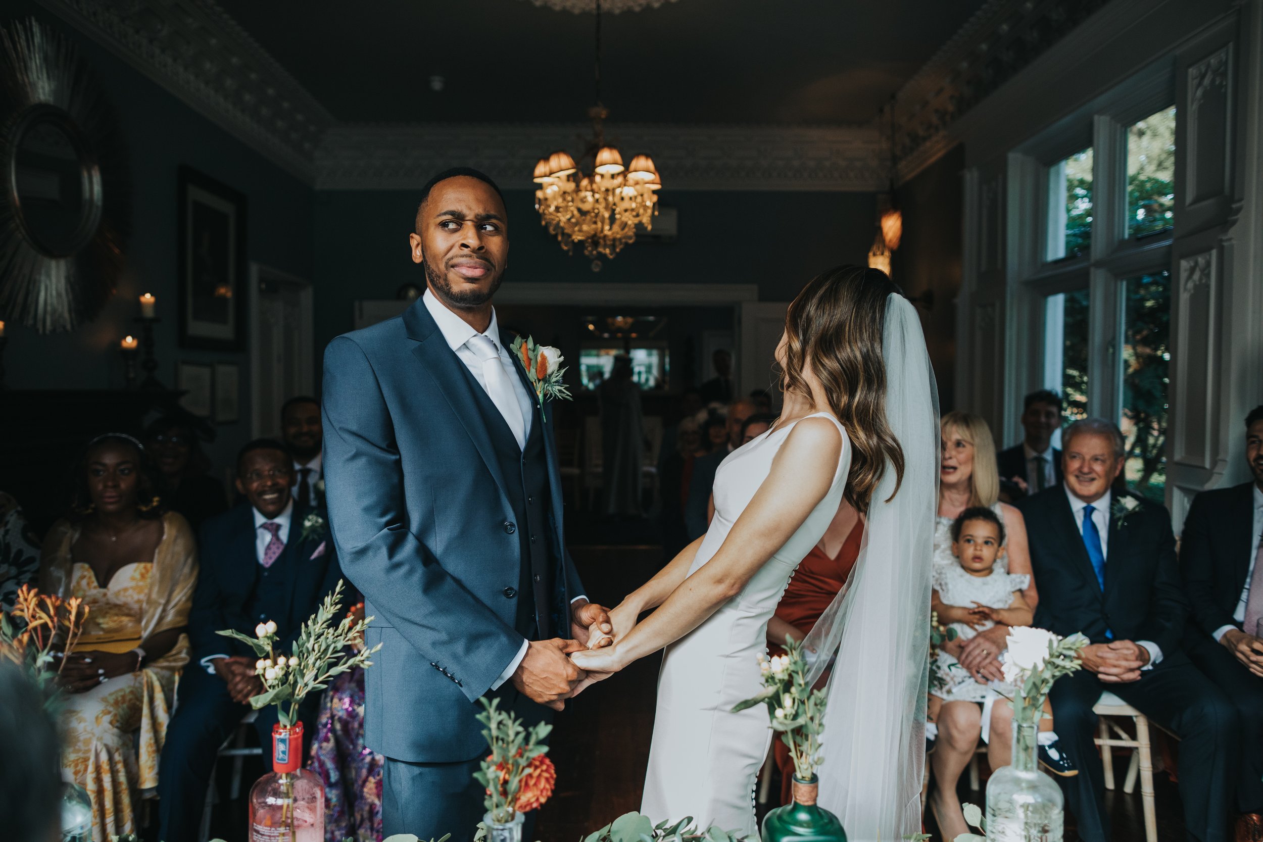 Groom gives a confused look as Bride looks back at the guests and laugh. 