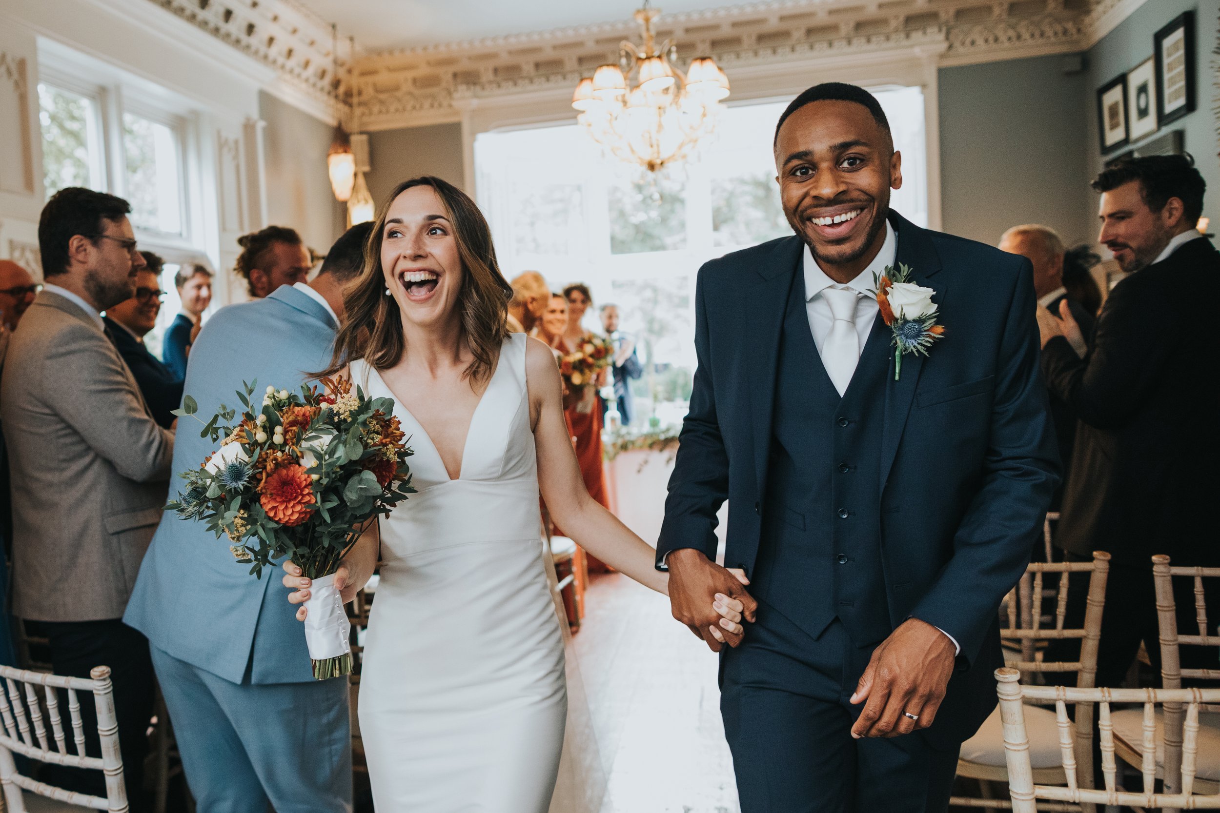 Bride and Groom laughing as they leave the wedding ceremony. 