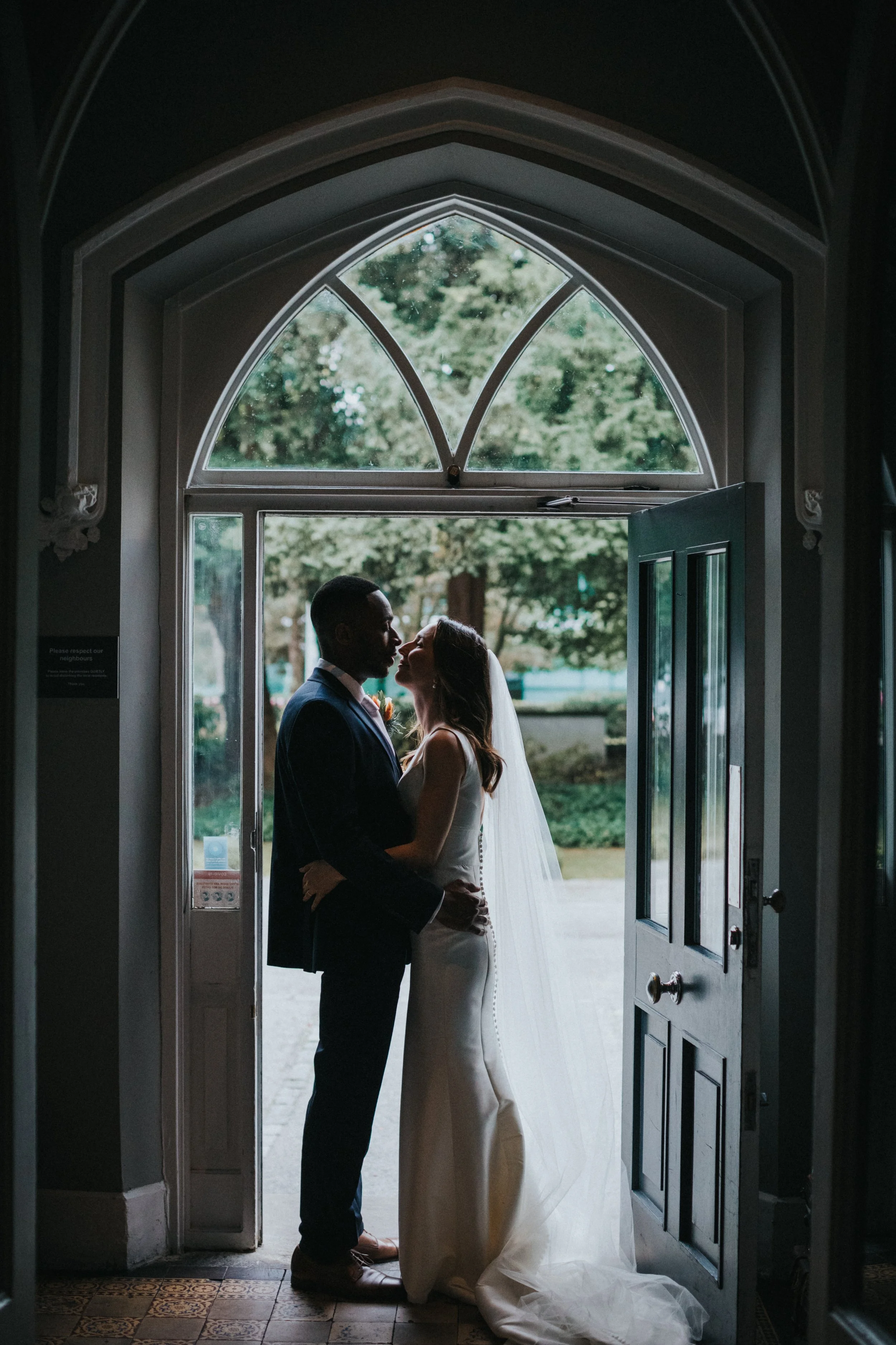 Bride and Groom stand in doorway together at Didsbury House Hotel.