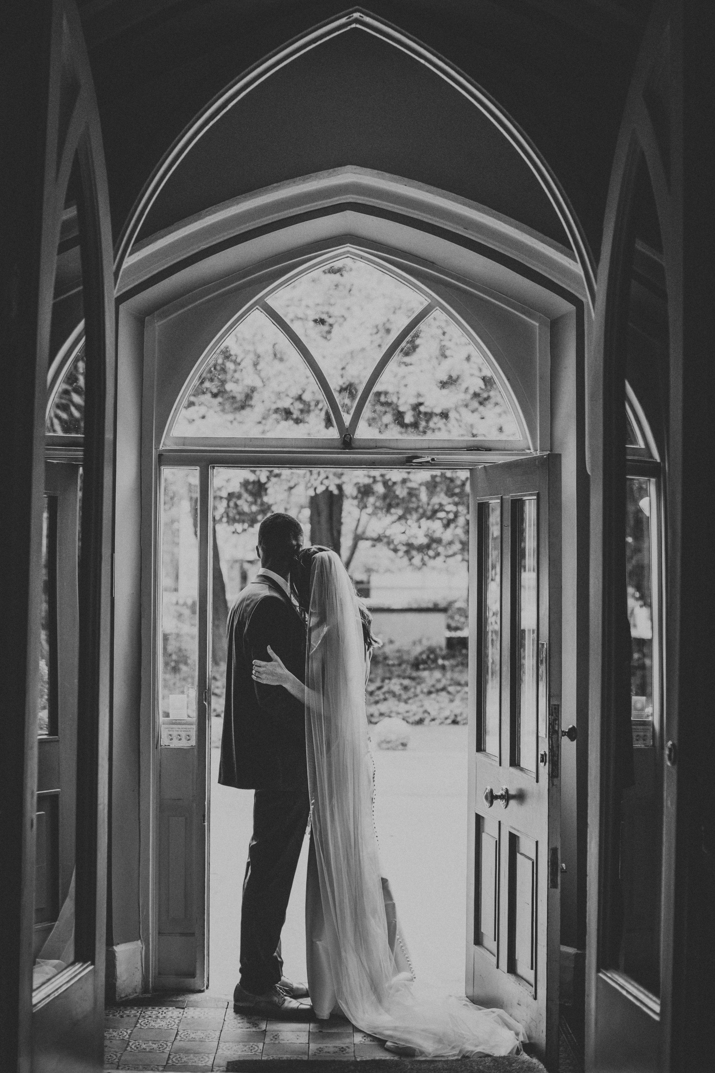 Bride and groom have a cuddle in the doorway at Didsbury House Hotel. 